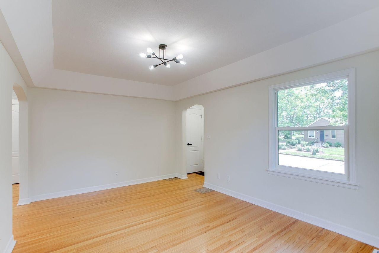 empty wood floor living space with modern light fixture