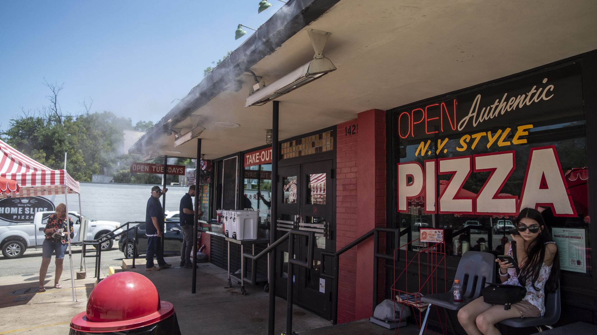 A photo of Homeslice Pizza with the words "Authentic N.Y. Style Pizza" written on the window.