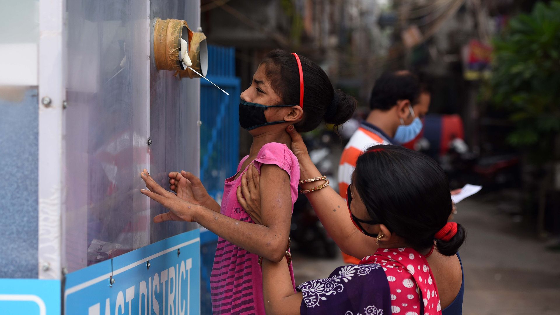 A health worker collects a swab sample from a girl for coronavirus testing, at New Ashok Nagar, on August 18, 2020 in New Delhi, India.
