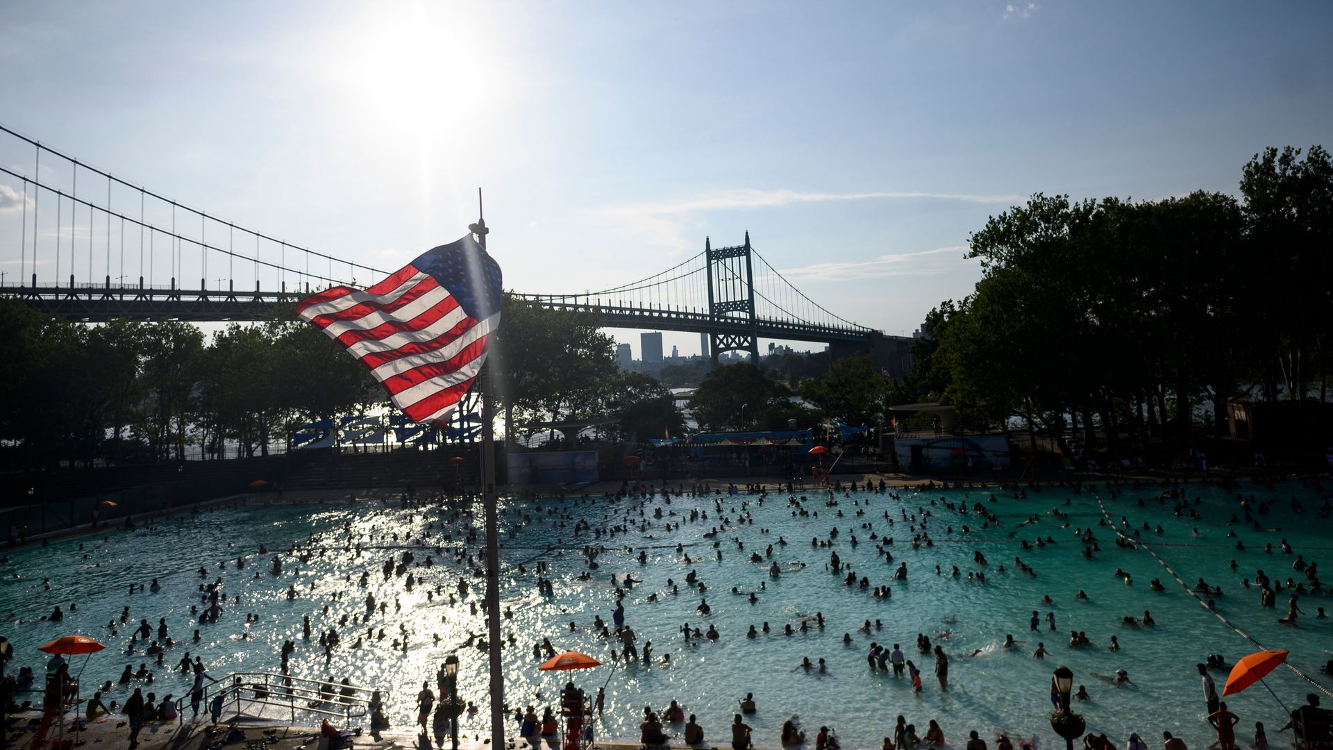A US flag flies overhead as people enjoy the Astoria Pool on a hot afternoon in the borough of Queens, New York City, on July 20.