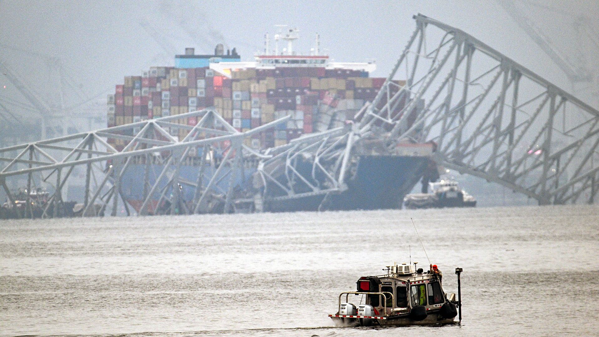 The cargo ship sits in the water behind the destroyed Baltimore bridge.