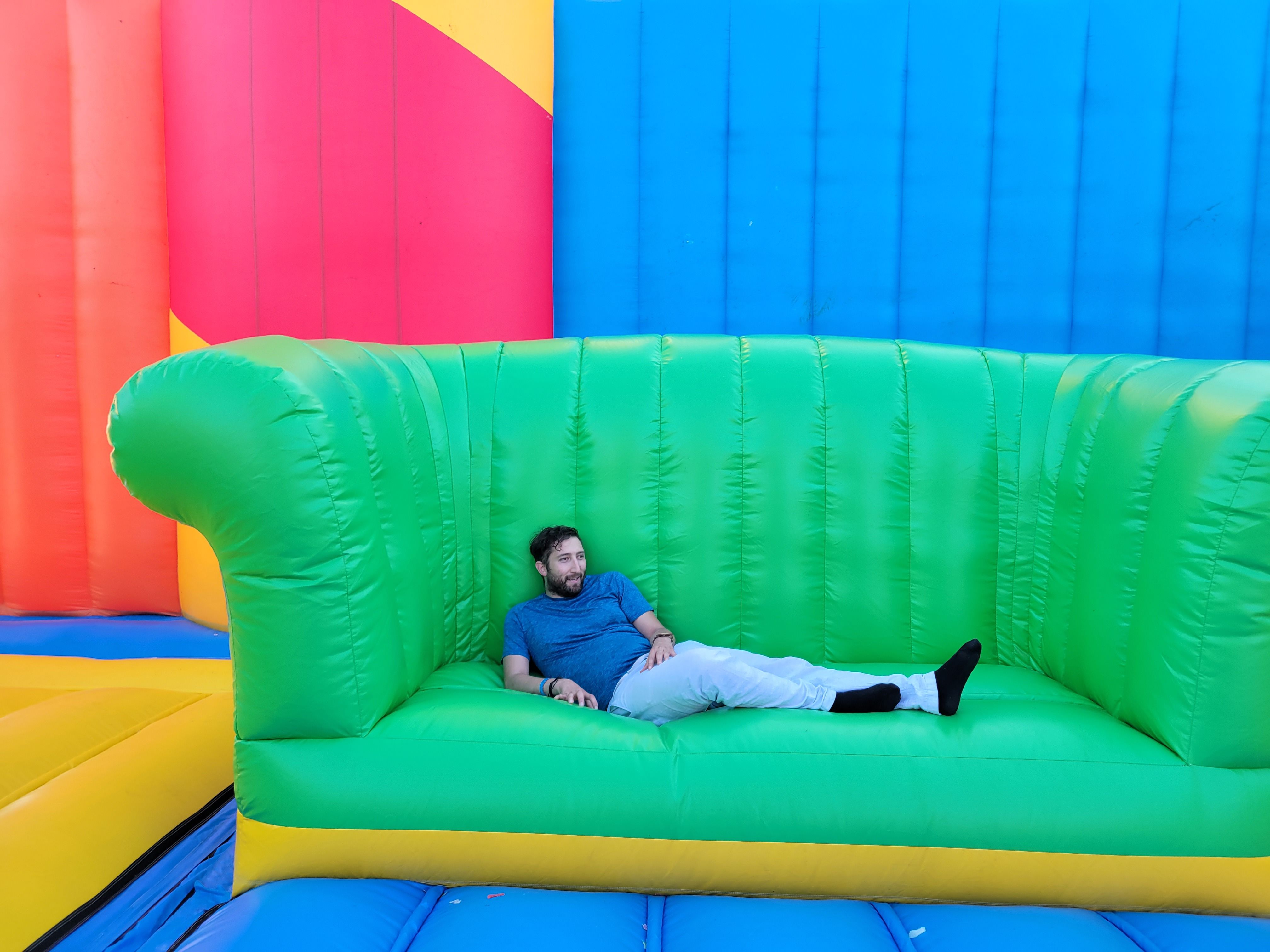 Axios reporter Isaac Avilucea lounges on an oversized inflatable couch.