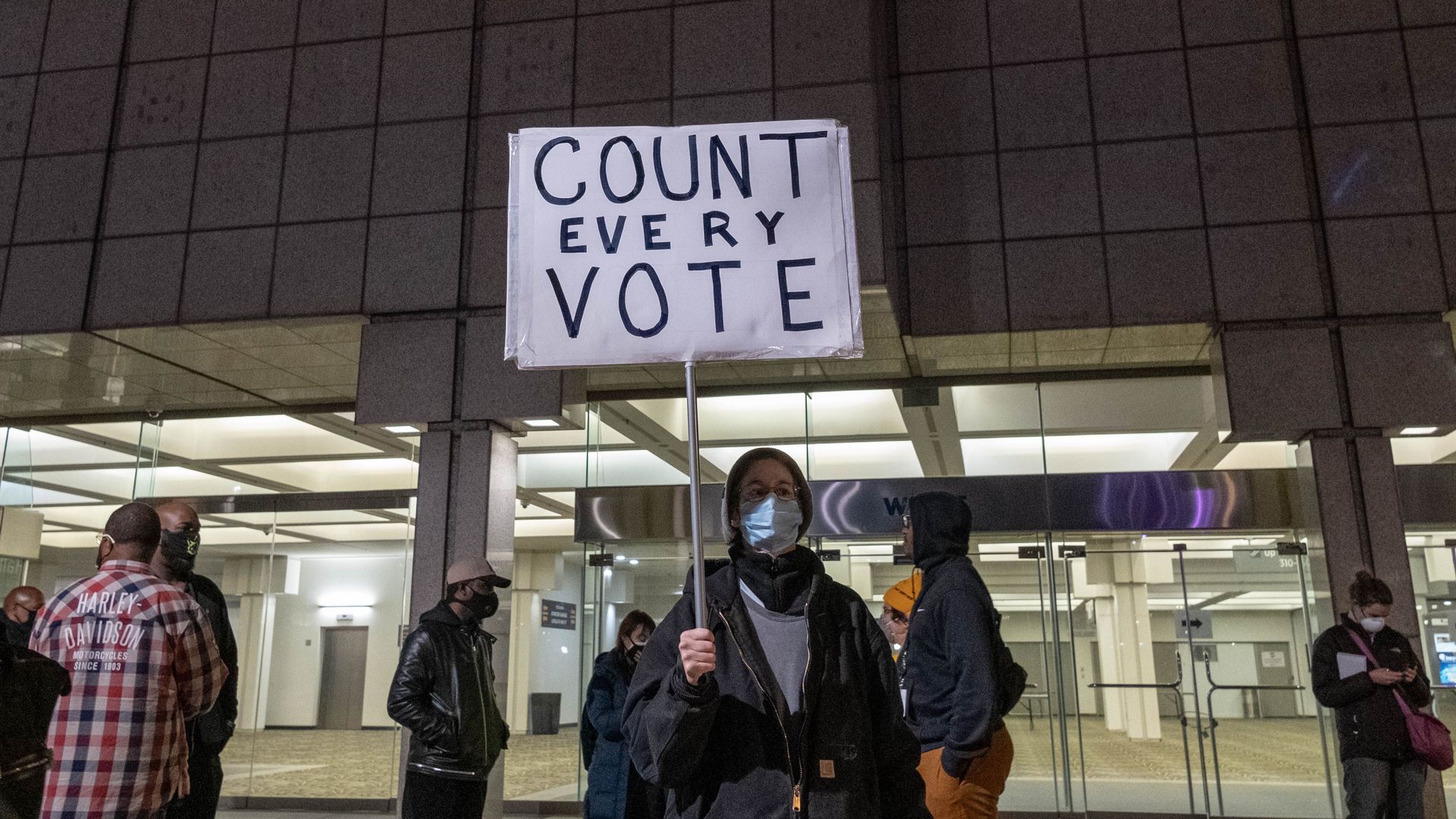 A protester holds a "Count every vote" sign outside of the TCF center where ballots are being counted in downtown Detroit, Michigan on November 4, 2020.