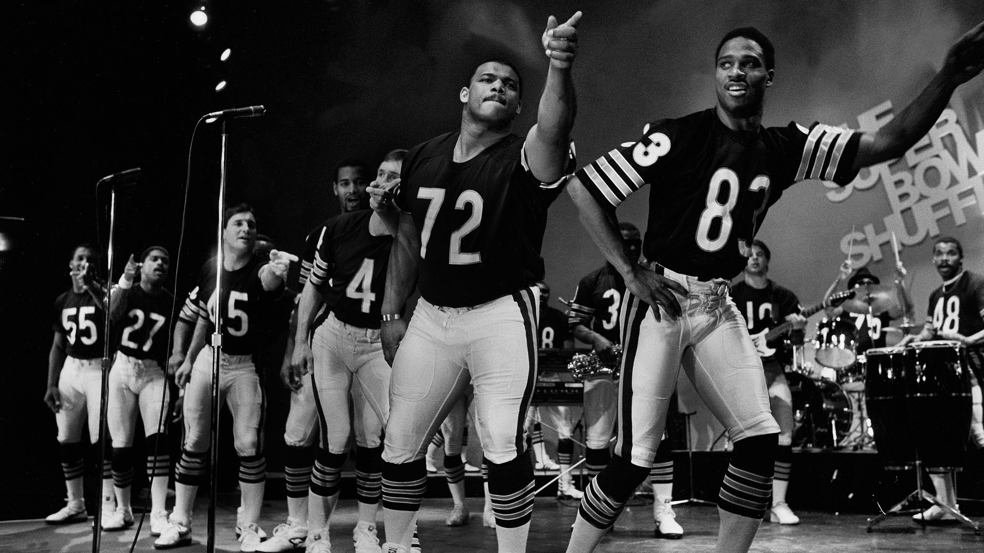 Photo of men in football uniforms dancing on a stage 