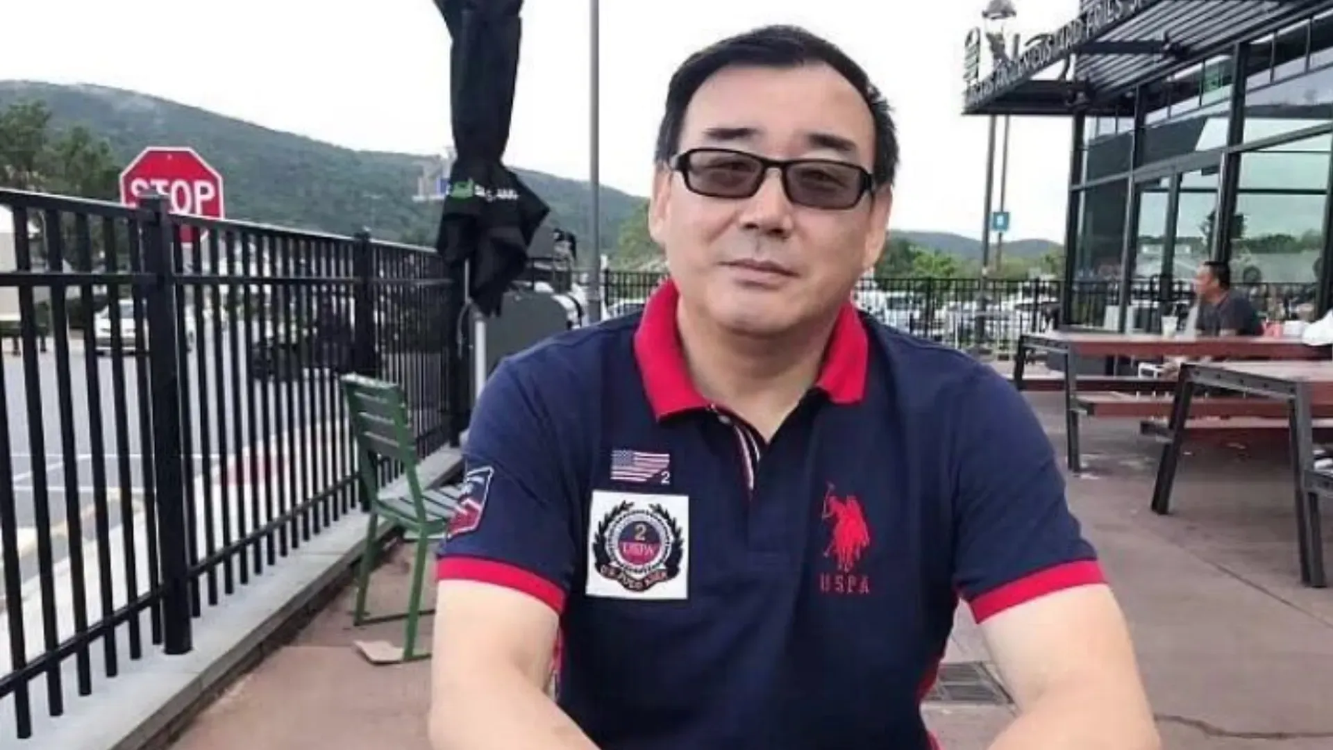 Detained Chinese-Australian novelist and former diplomat Yang Hengjun posing for a photo at an undisclosed location with a mountainous backdrop.