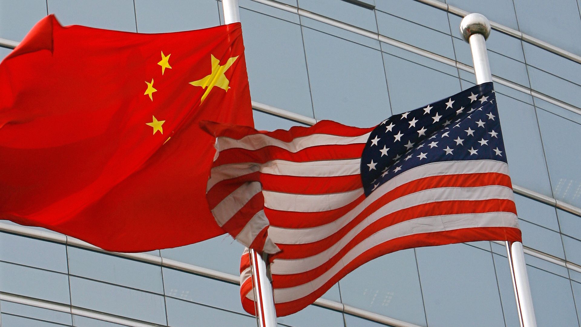 A US and a Chinese flag wave side by side