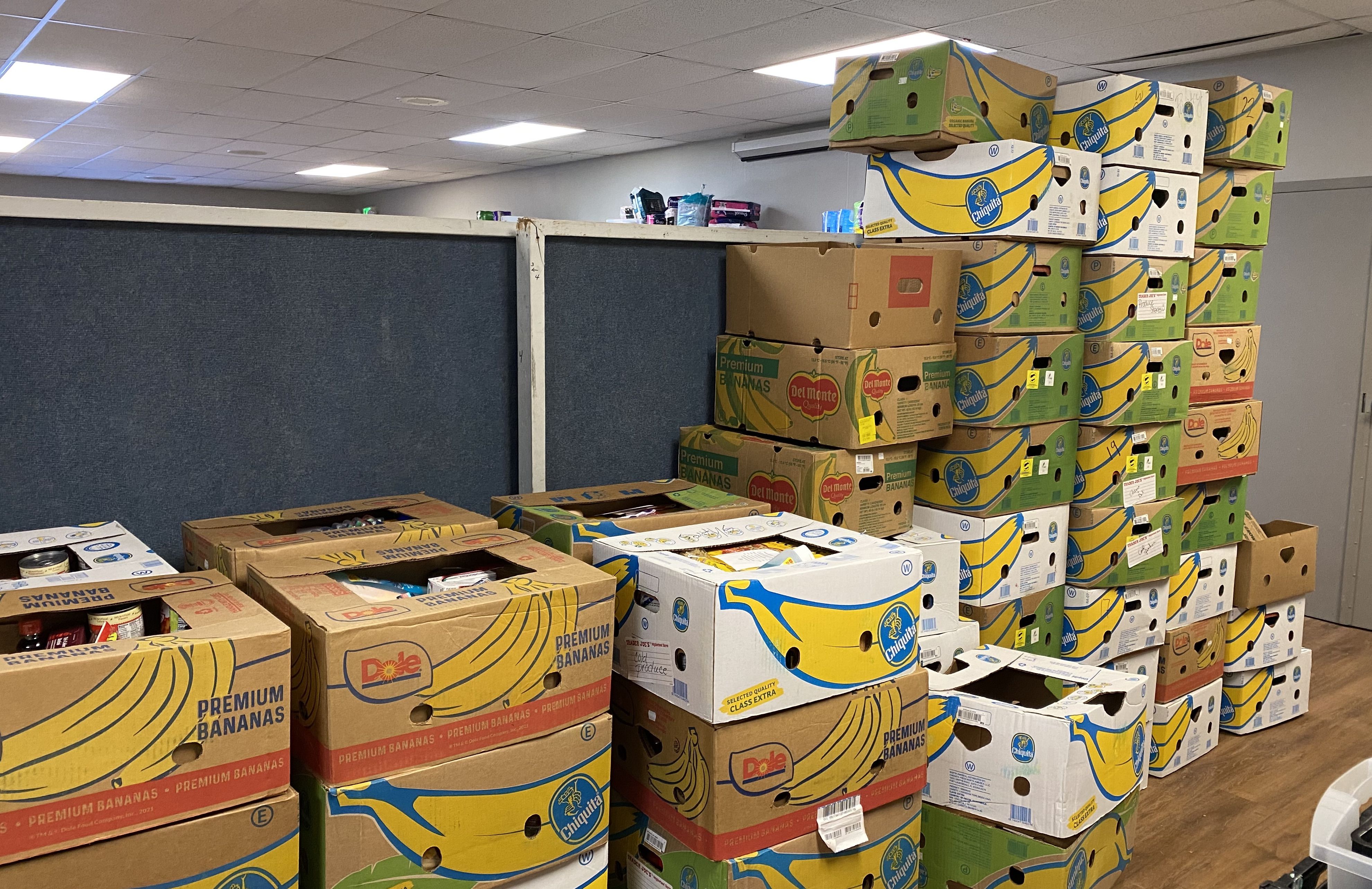Piles of boxes of cardboard food are stacked toward the ceiling