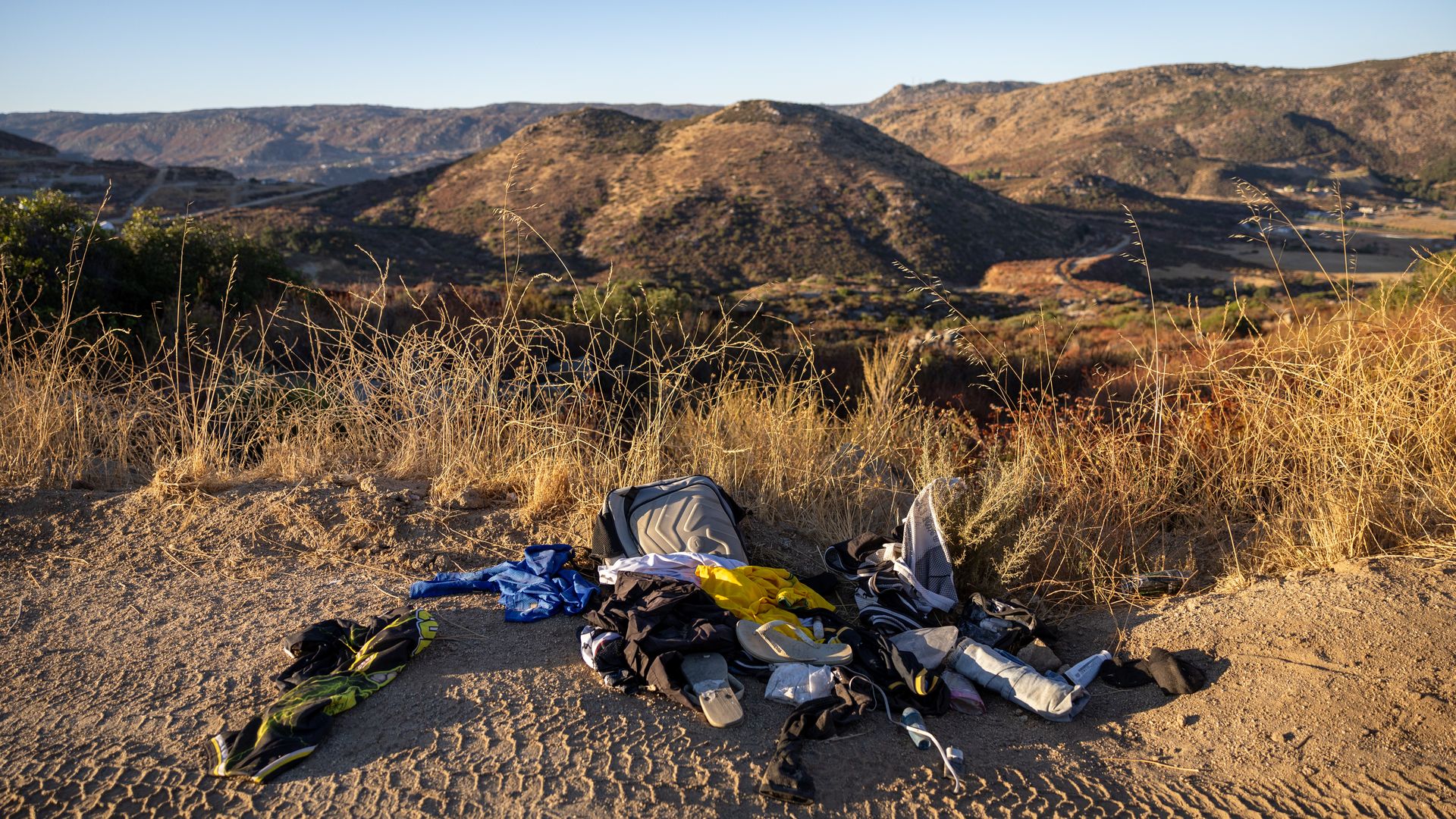 A pile of clothes in desert terrain with small mountains in the background
