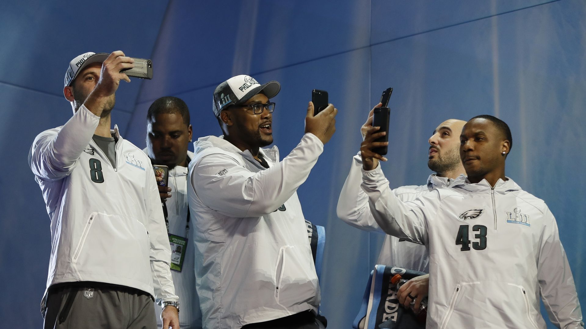 Photo of Philadelphia Eagles taking pictures with their phones at Super Bowl opening night 