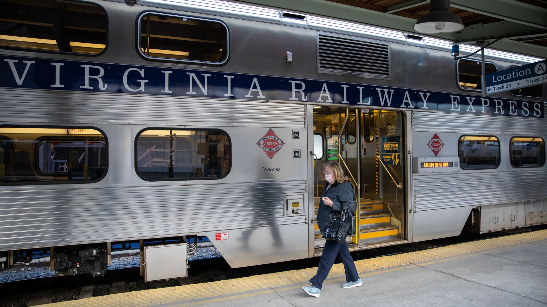 A person walks on a VRE train platform.