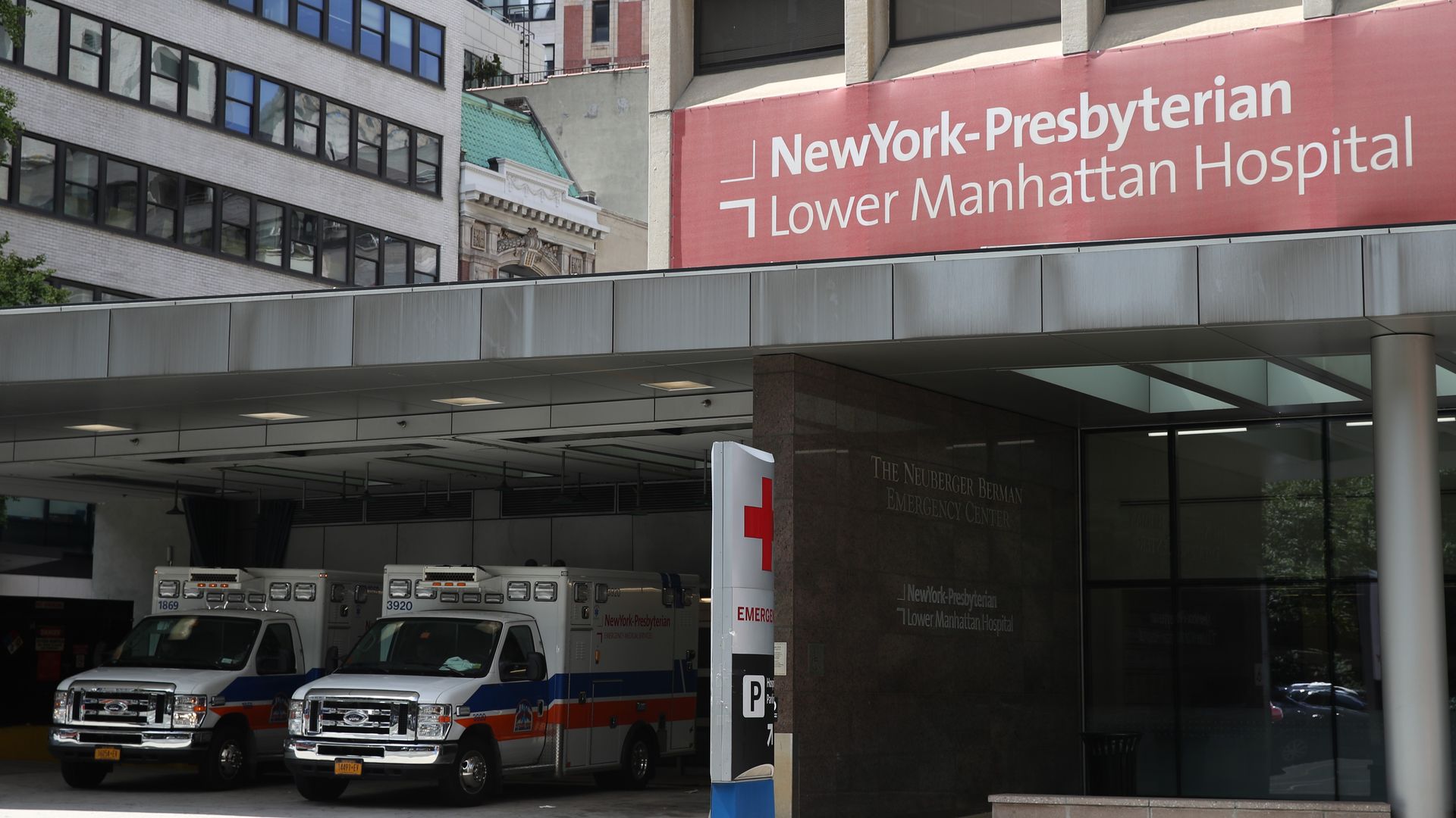 Red NewYork-Presbyterian Lower Manhattan hospital sign and building with ambulances.