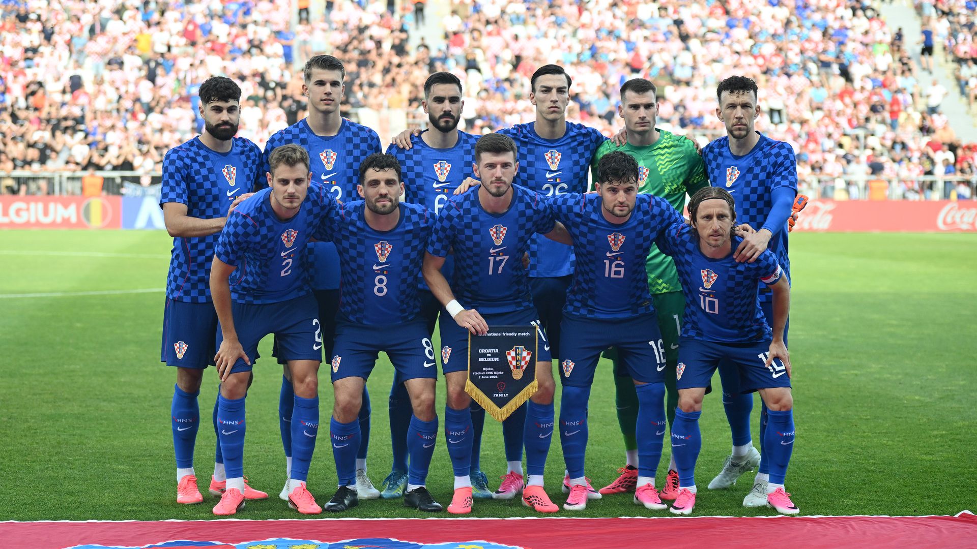 Players of Croatia pose for a team photograph on a soccer pitch.
