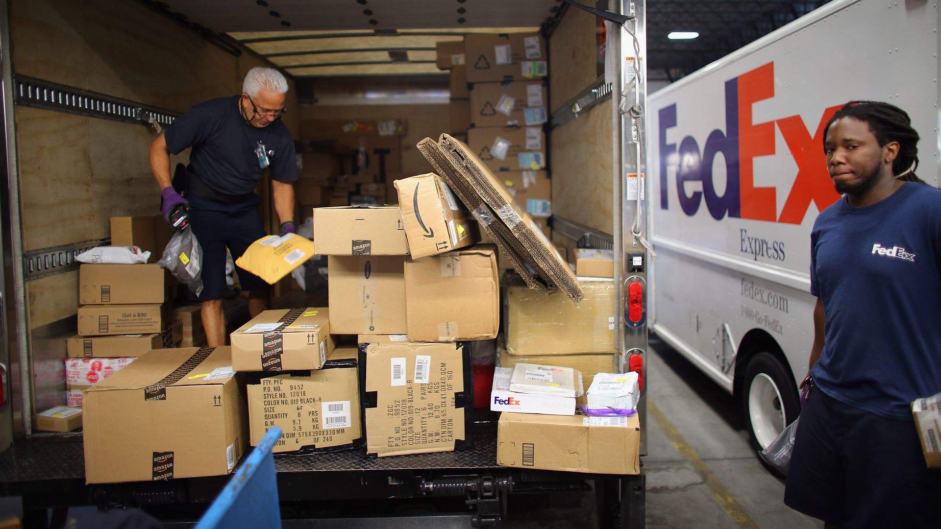 Fedex workers loading packages into a truck