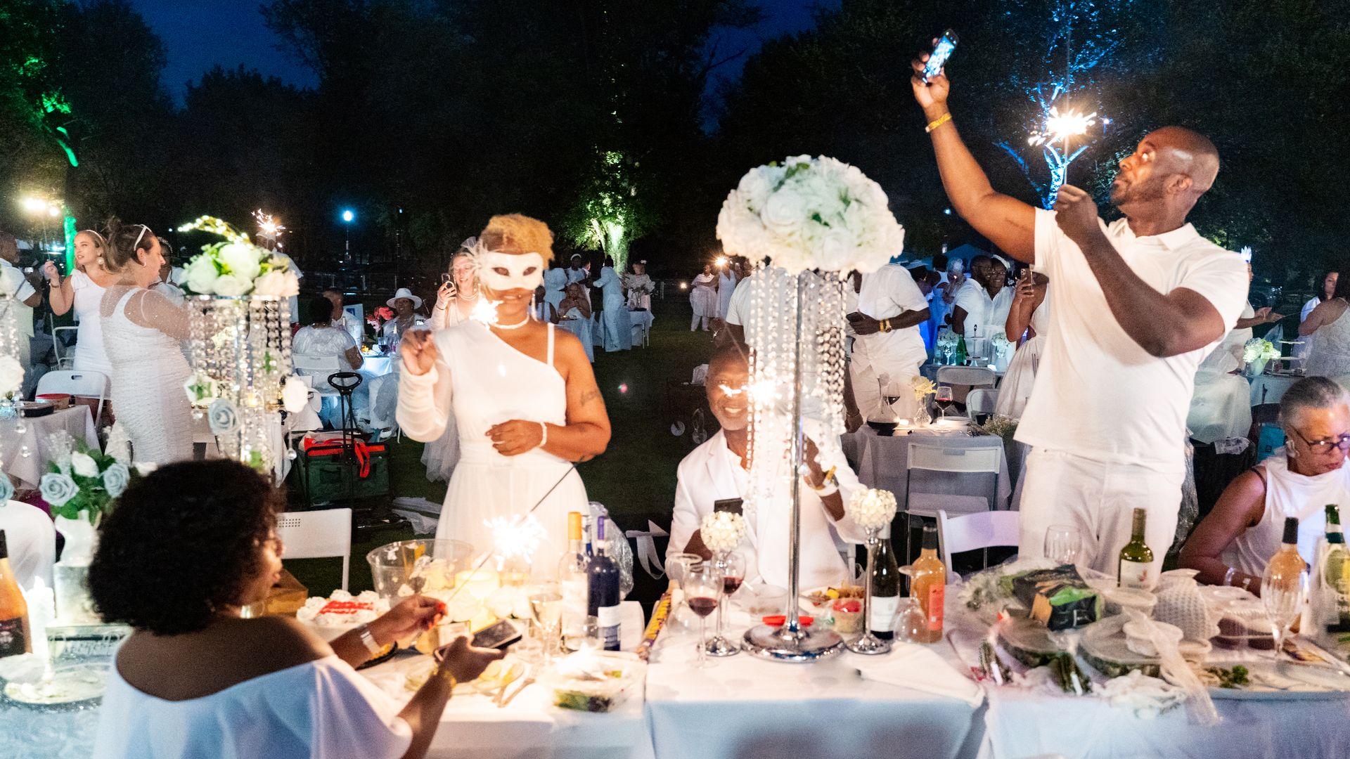 A group of people dressed in white around a white table