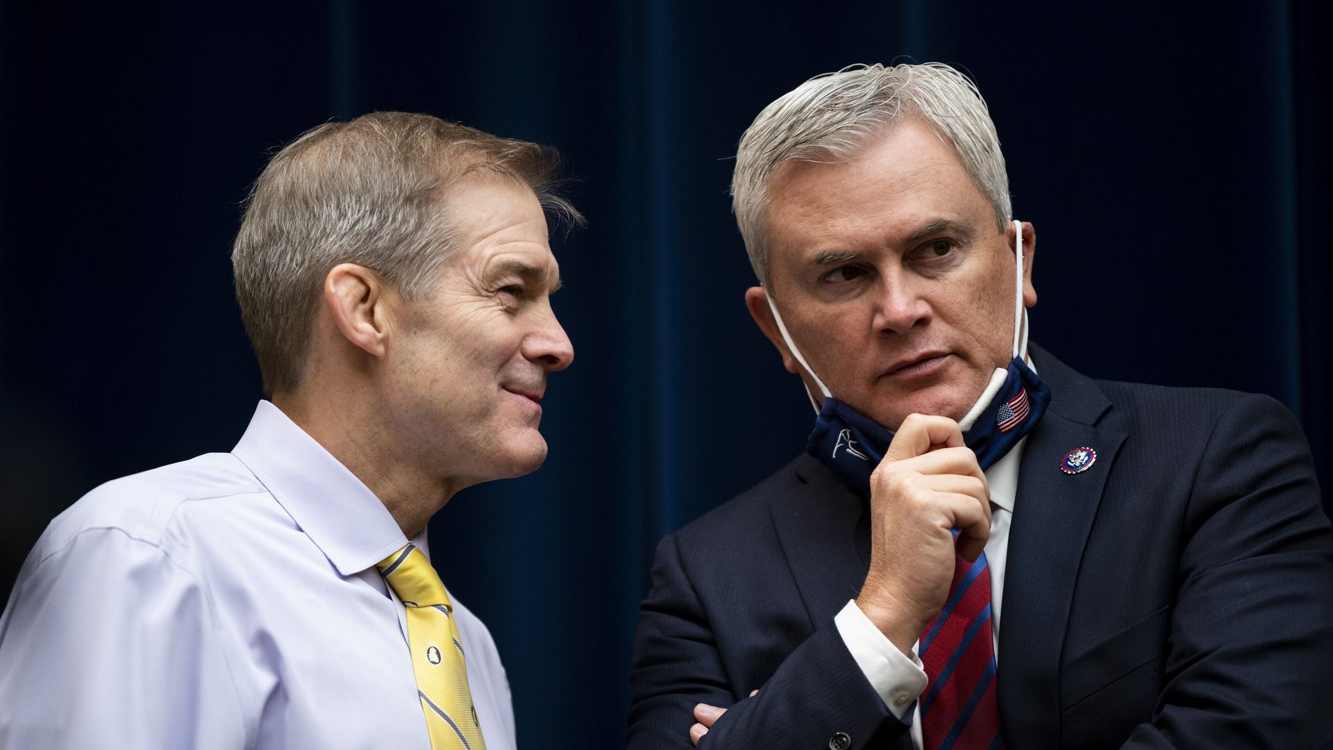 Reps. Jim Jordan, wearing a light blue shirt and yellow tie, and James Comer, wearing a blue suit, white shirt, red and blue striped tie and blue mask.