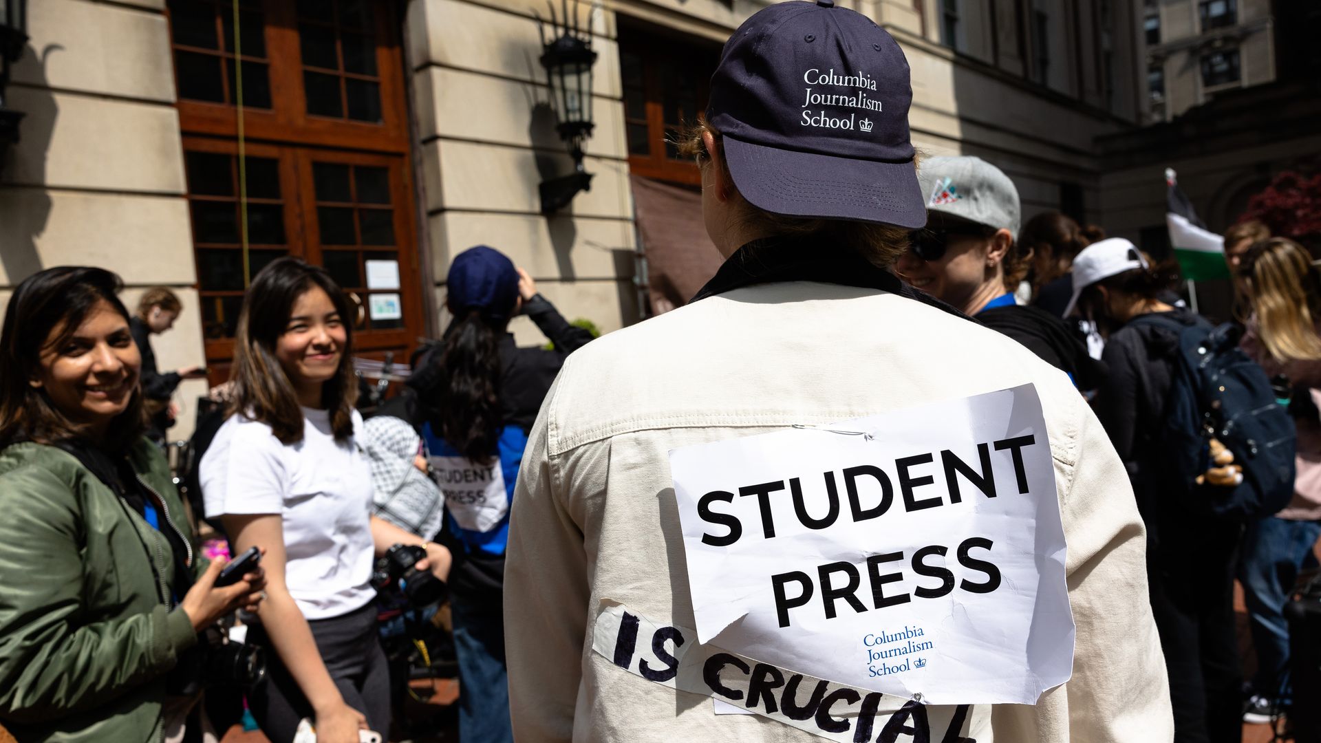 A Columbia Journalism student with a "student press" sign in New York City in April 2023.