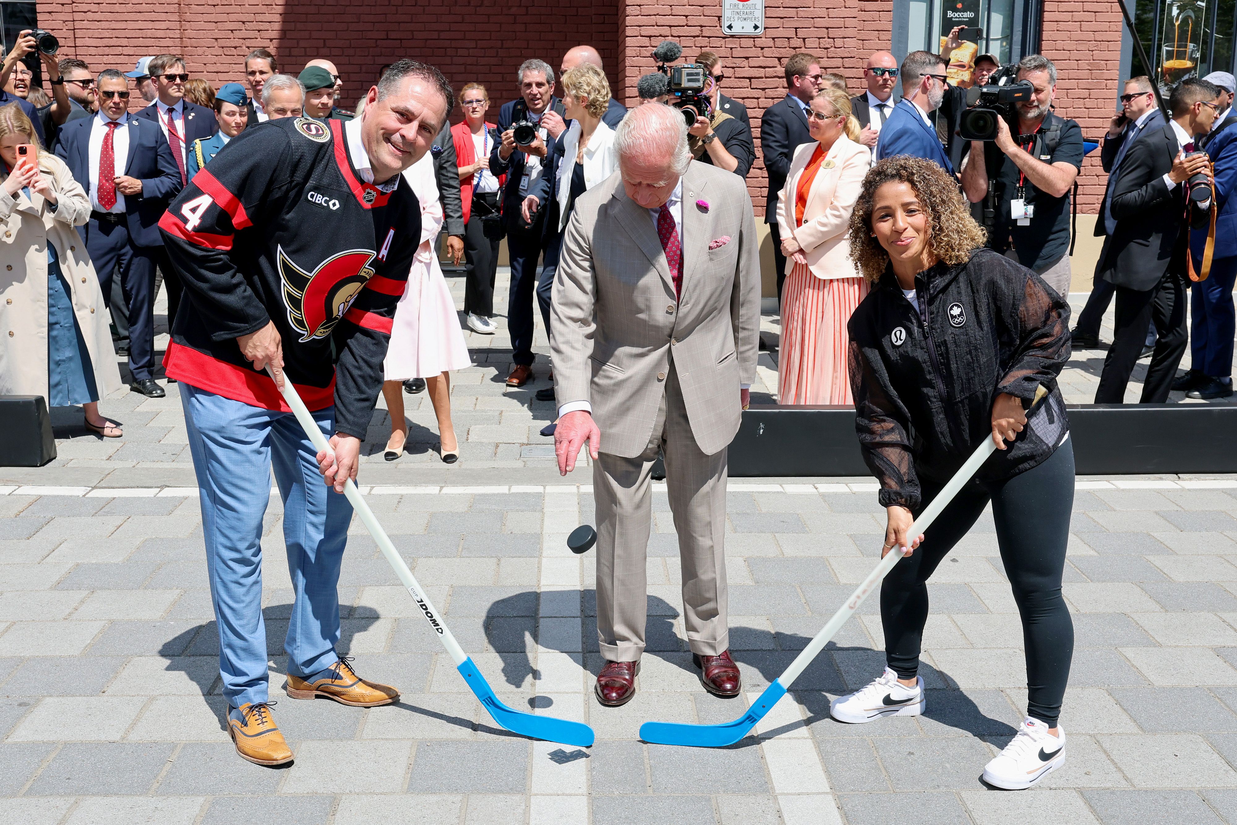 King Charles III drops a puck during an event in Ottawa yesterday during the first day of his visit to Canada.