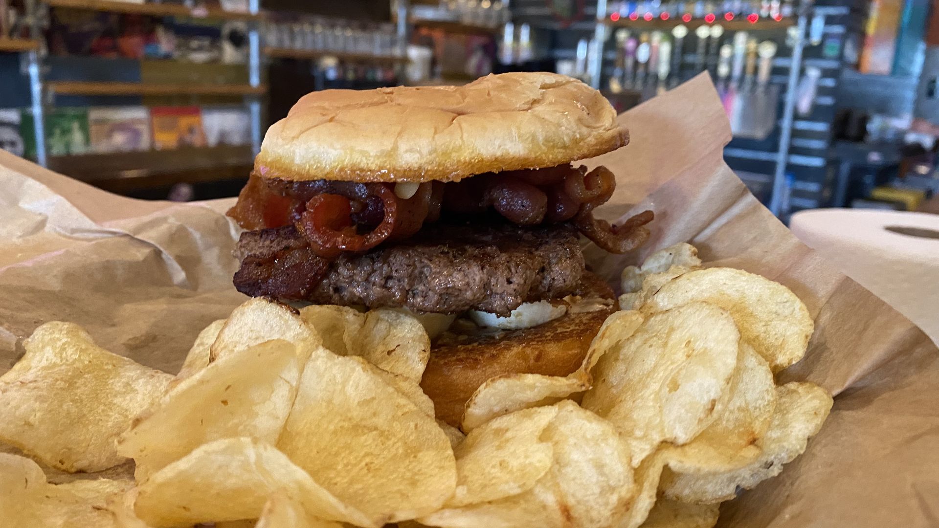 A photo of a burger with a side of potato chips. 