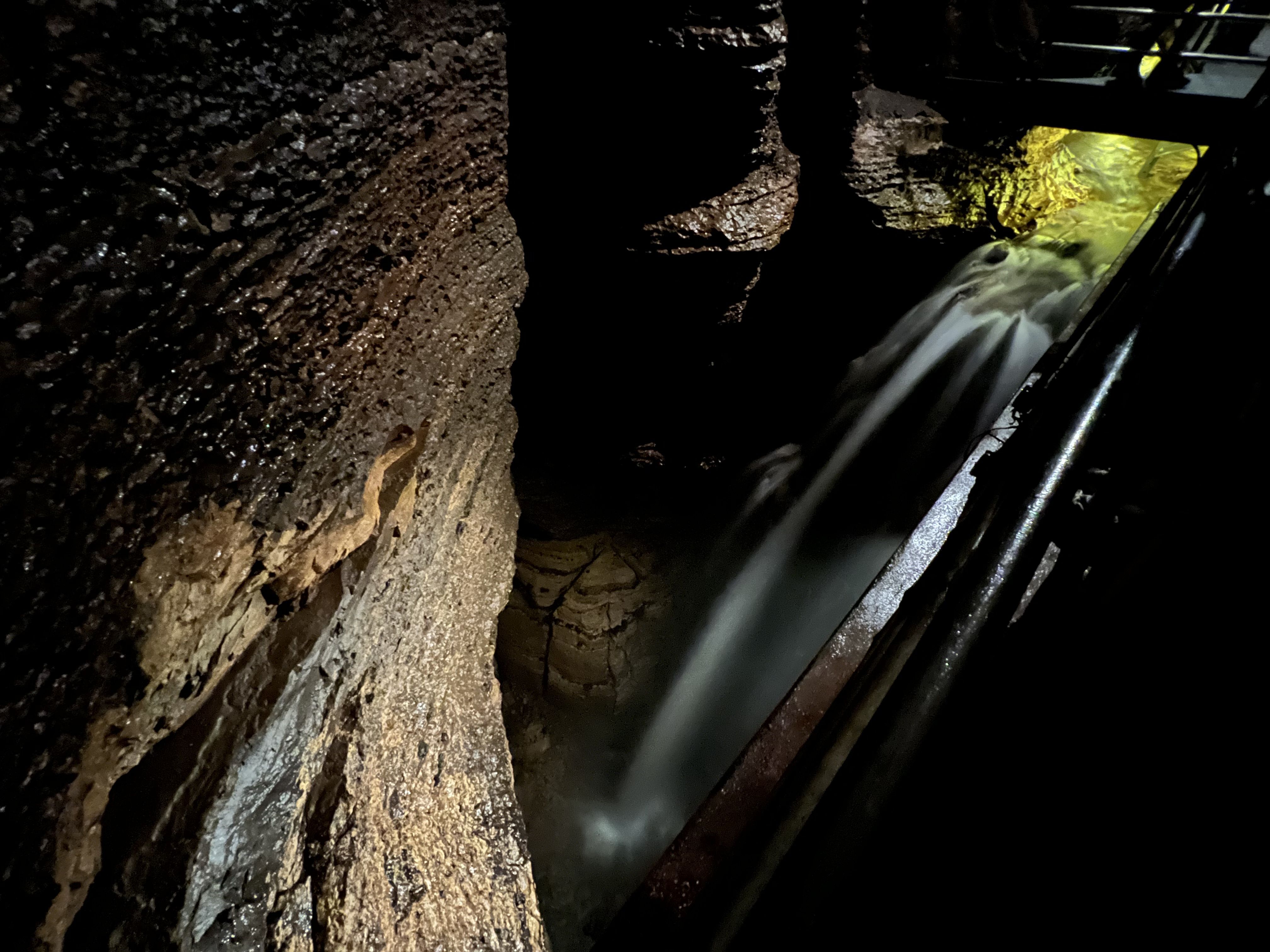 An underground waterfall tumbles 50 feet deeper into a hole in a cave beneath a walkway 