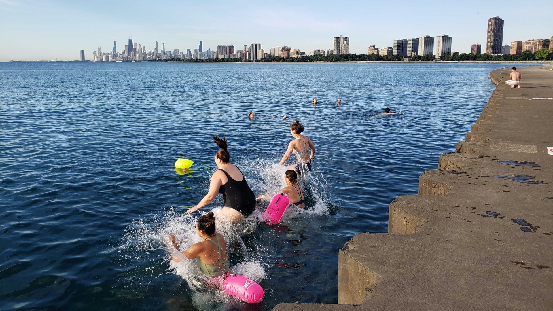 Photo of swimmers jumping in a lake.
