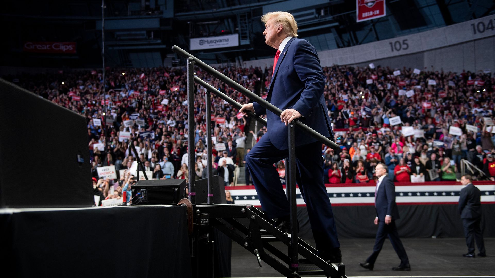 Donald Trump walks up stairs at arena