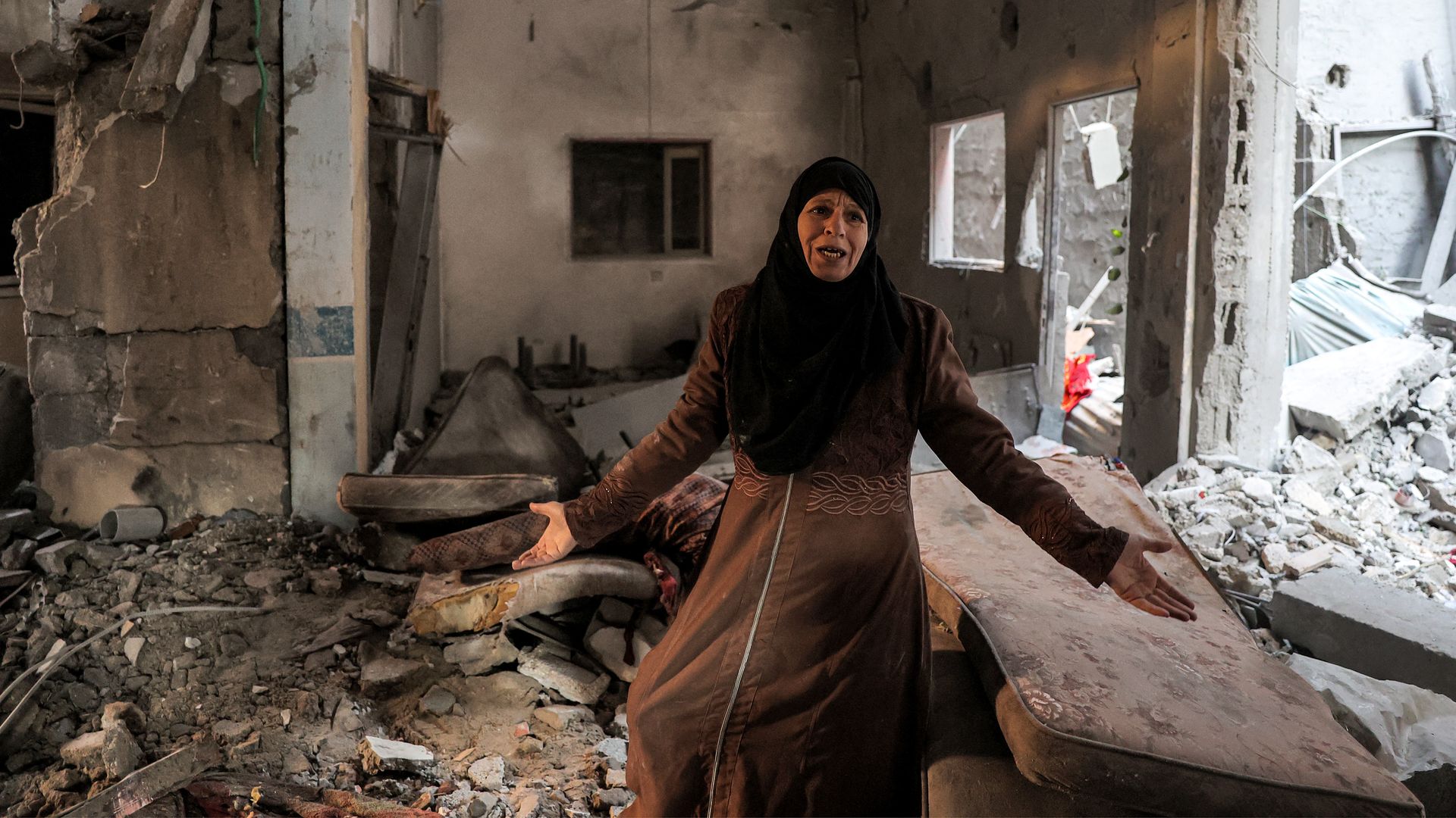 A Palestinian woman cries as she inspects a heavily damaged apartment following Israeli bombardment on Rafah on Feb. 8