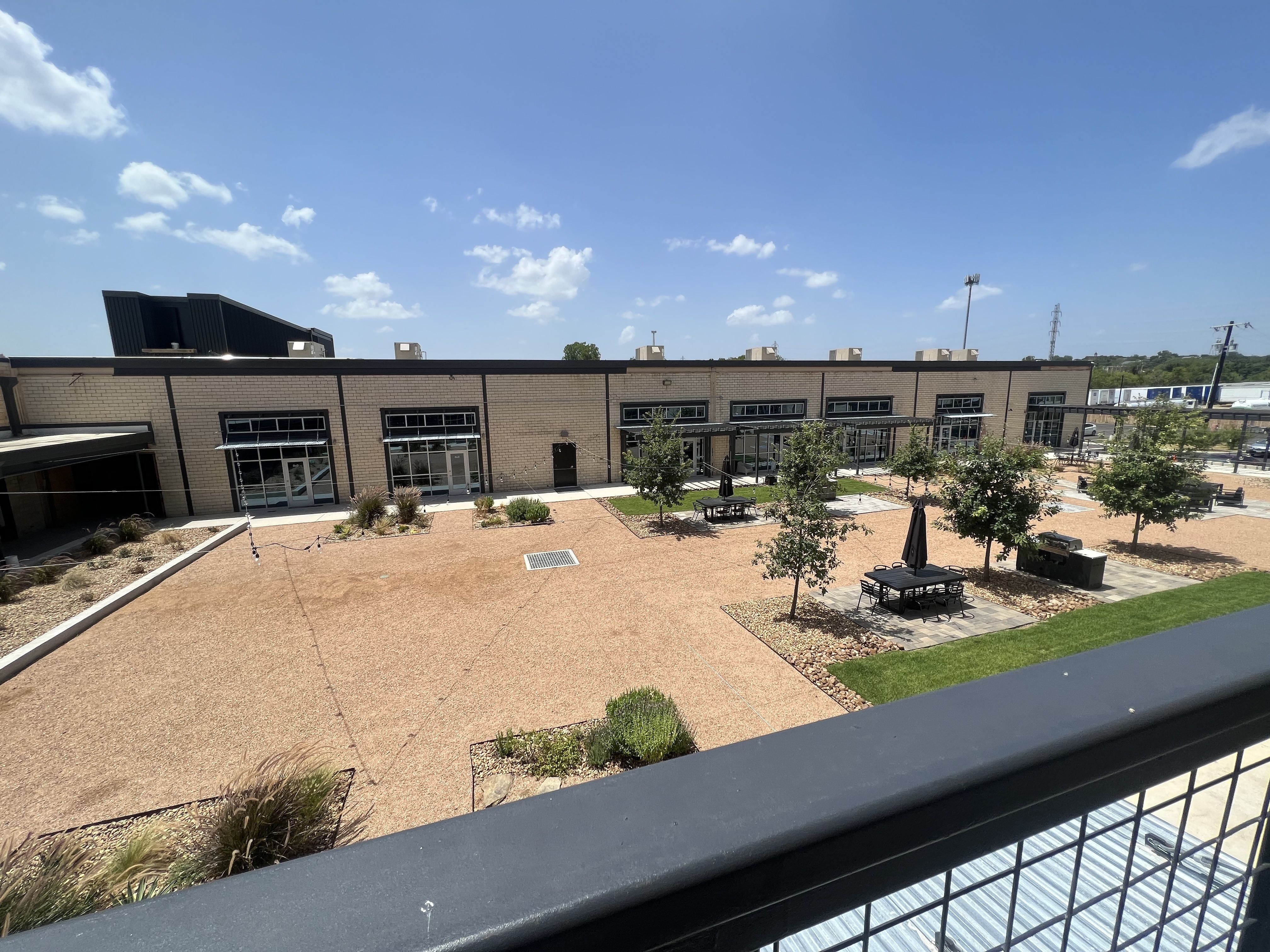 A wide open gravel courtyard with small trees.
