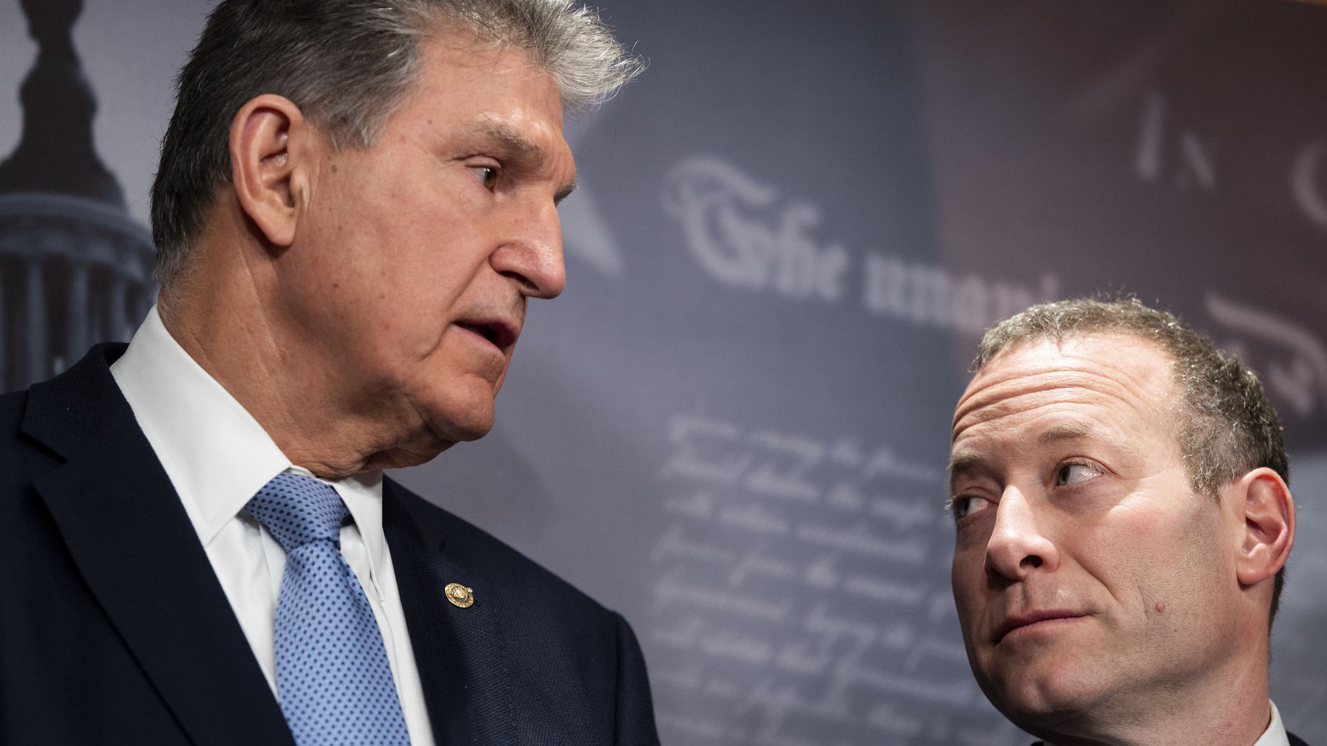 Sen. Joe Manchin (D-W.Va.) and Rep. Josh Gottheimer (D-N.J.) look at one another at an event on Capitol Hill.