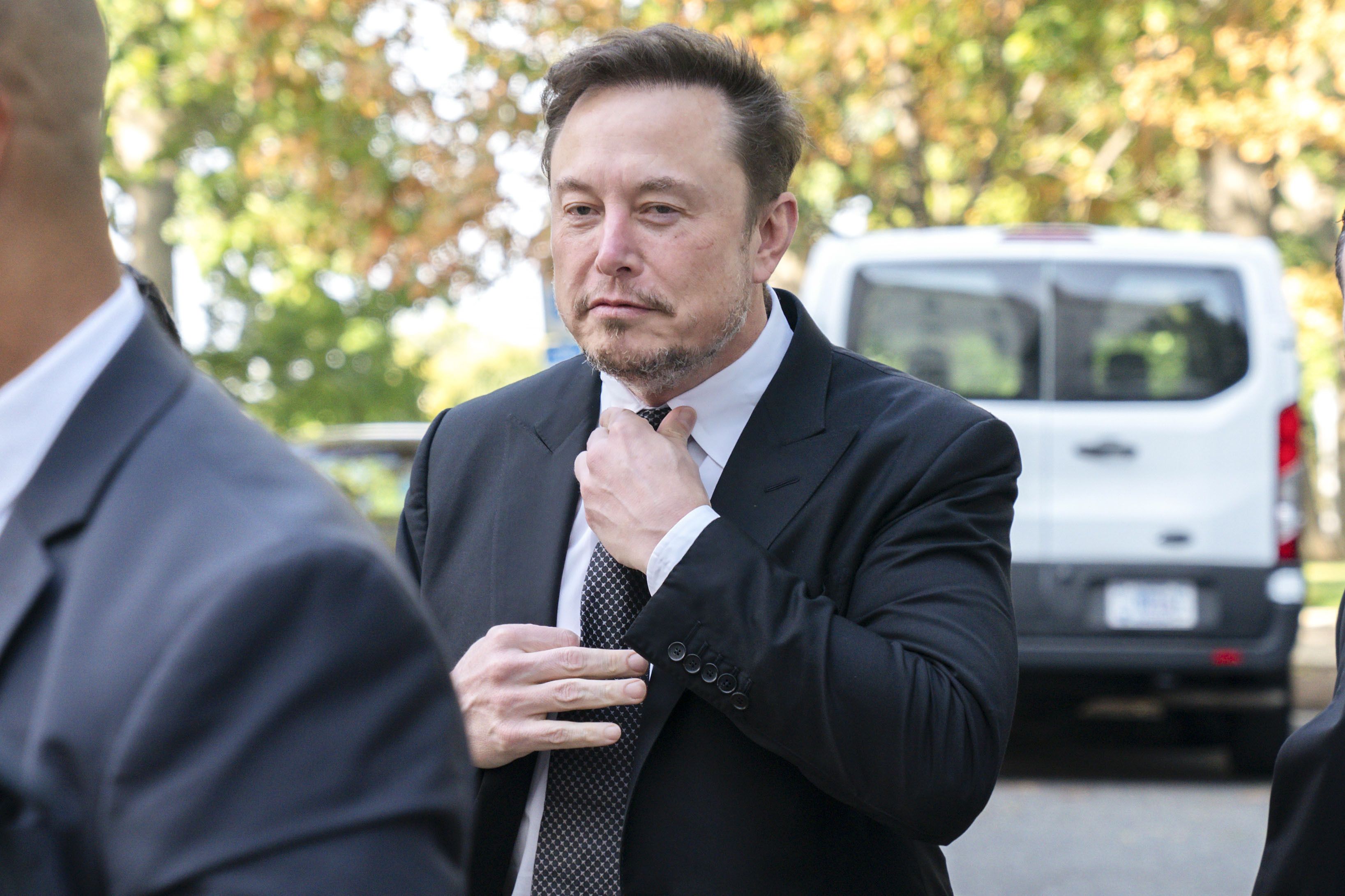 Elon Musk, CEO of X, the company formerly known as Twitter, tightens his tie as he arrives for a closed-door gathering of leading tech CEOs to discuss the priorities and risks surrounding artificial intelligence and how it should be regulated.