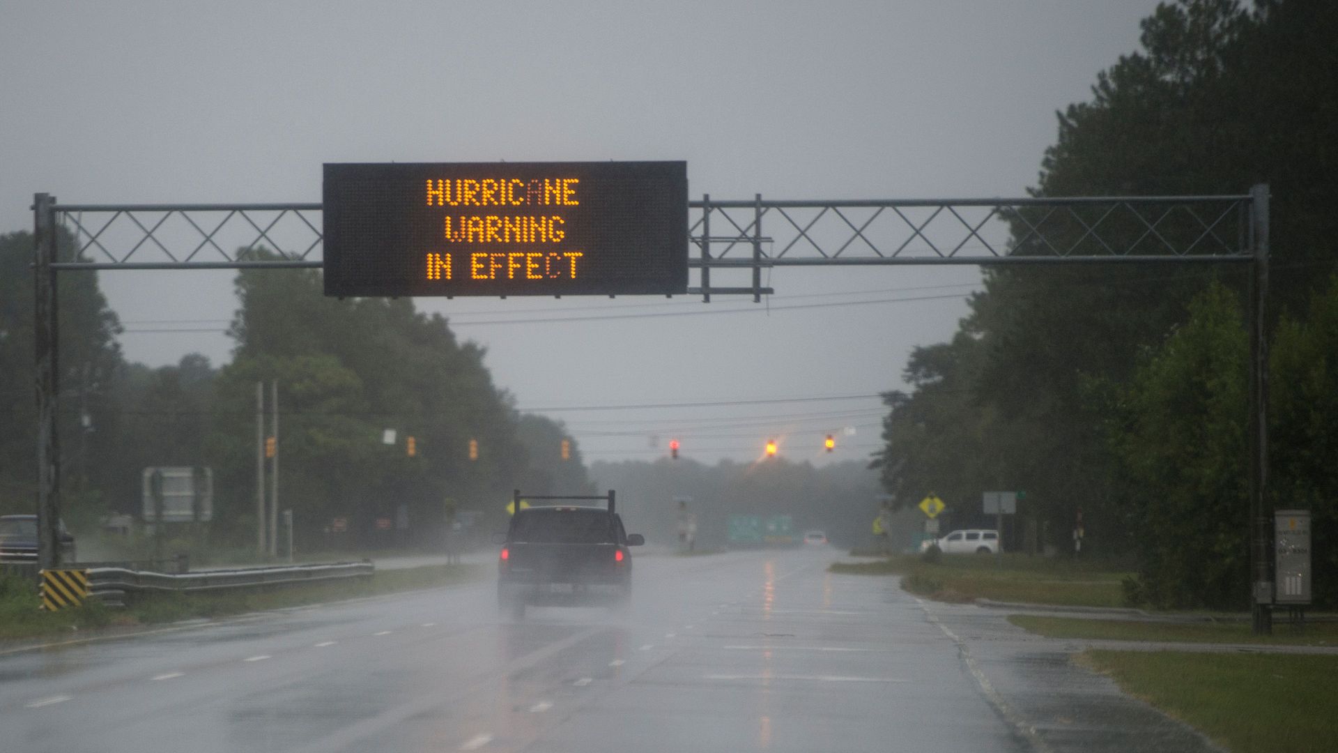 Hurricane warning in effect sign hangs above rainy street