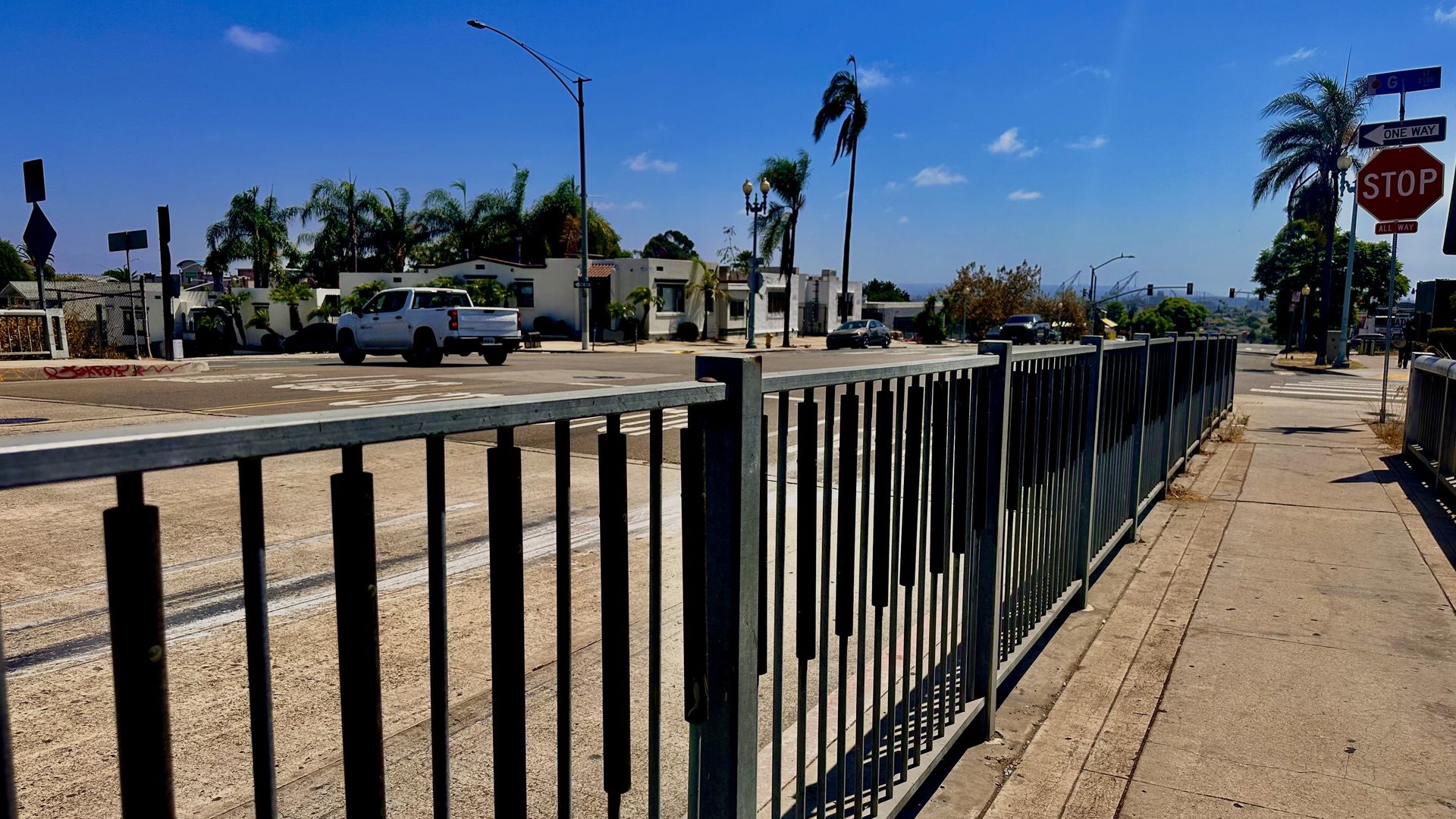 A railing along a sidewalk on a bridge over a freeway