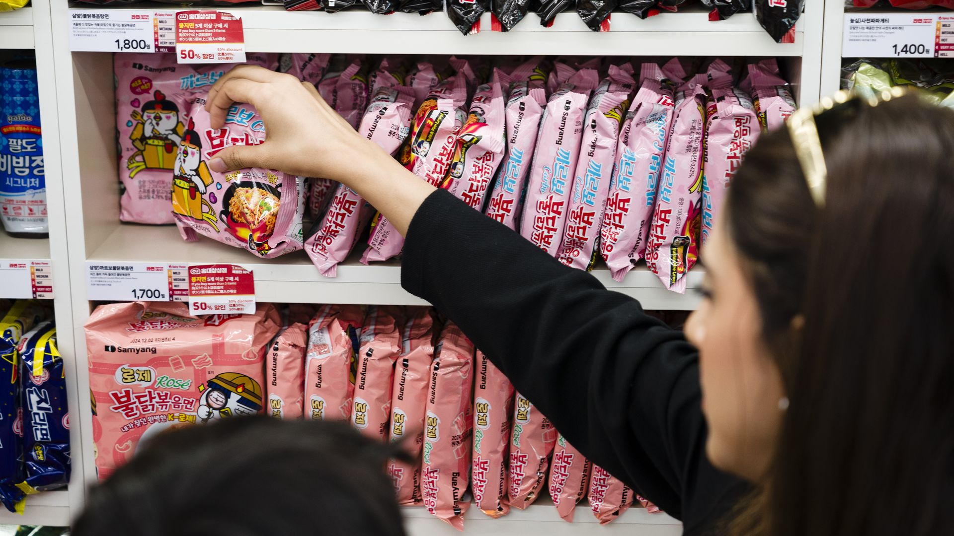 SEOUL, SOUTH KOREA - JUNE 17: The Anjum family, on vacation from Pakistan, picks out varieties of the Buldak Samyang instant noodles from the CU "Ramyun Library" convenience store, a popular tourist attraction, on Monday, June 17, 2024, in the Hongdae district of Seoul, South Korea. (Photo by Jintak
