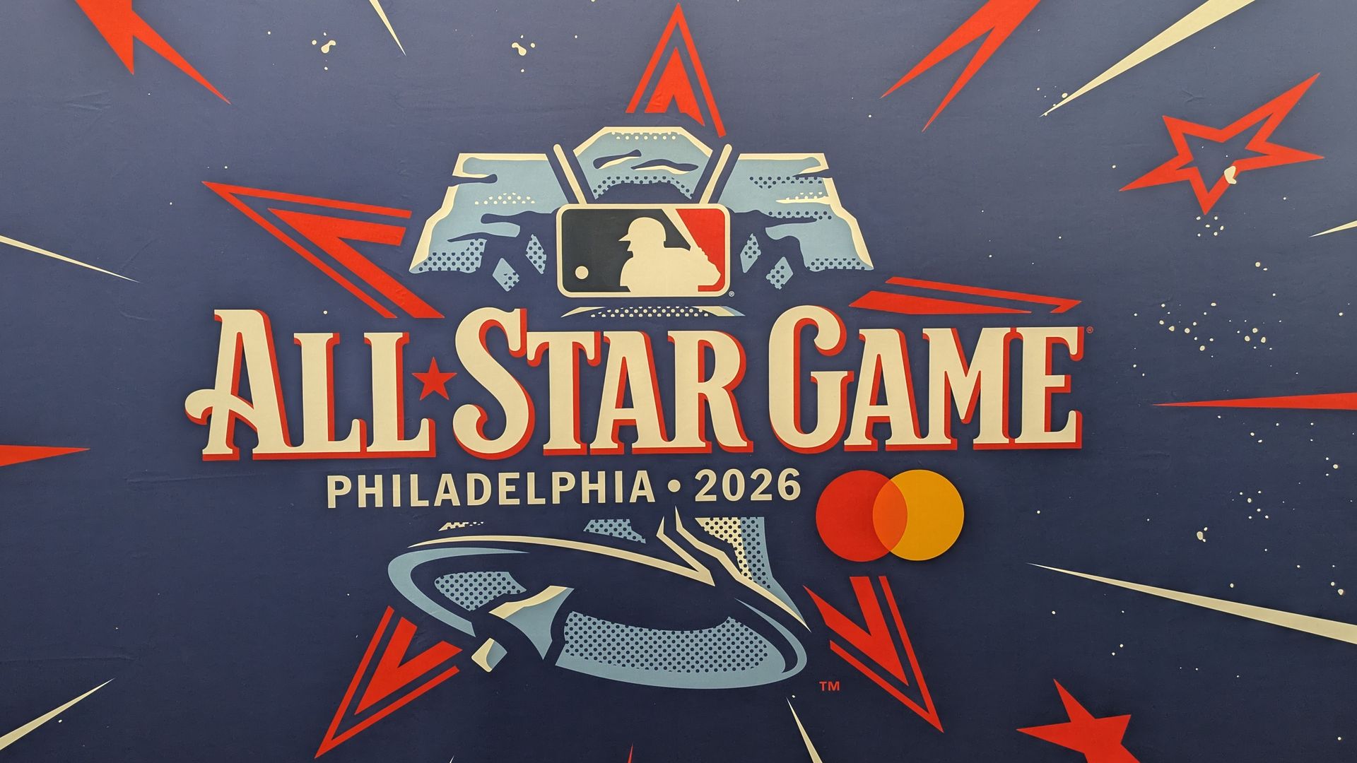 Blue backdrop featuring the MLB All-Star Game emblem: red, white, and blue graphics with stars and streaks, and the text "ALL-STAR GAME" with "PHILADELPHIA 2026."