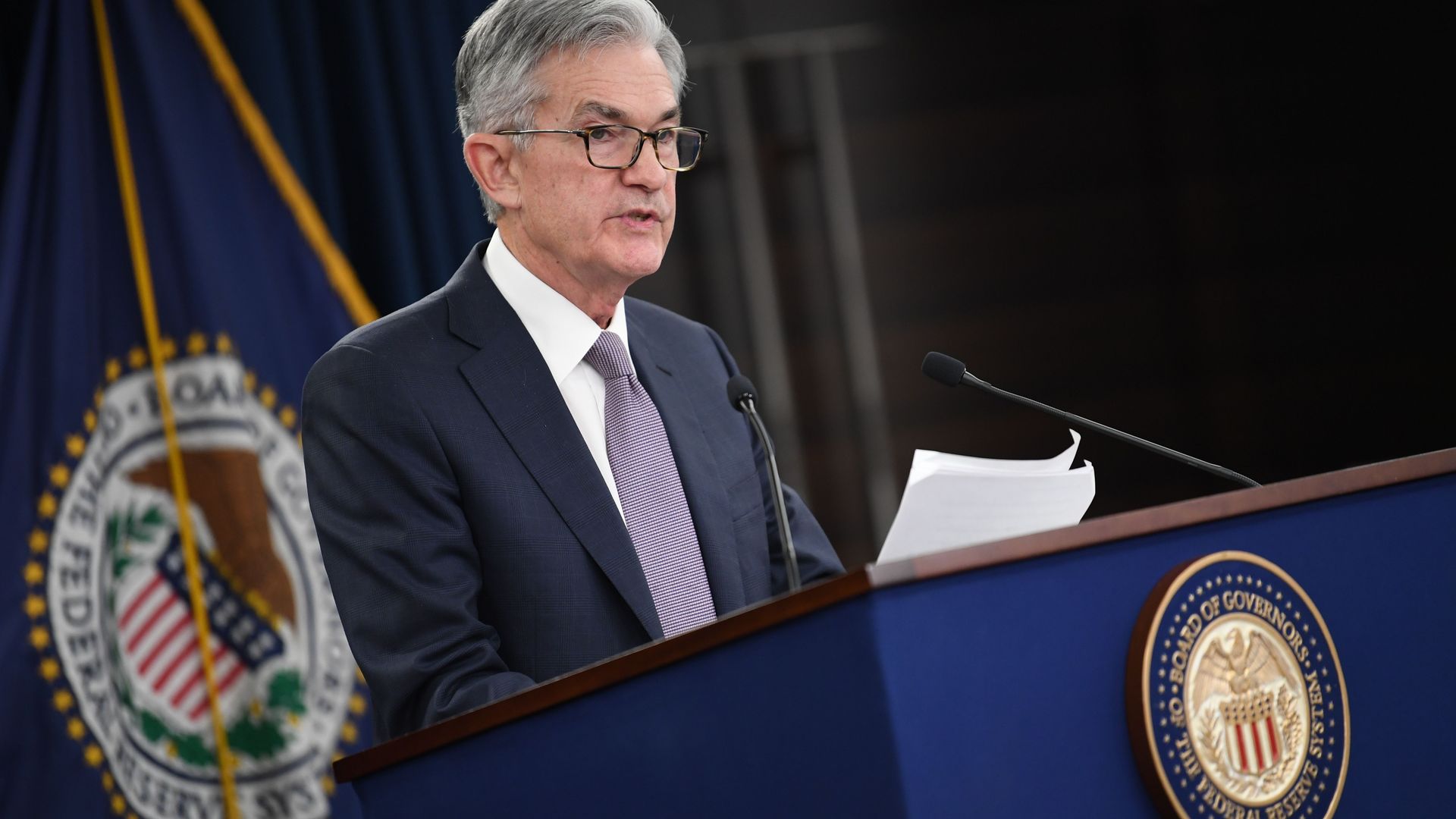 Federal Reserve Chairman Jerome Powell stands at a podium. 