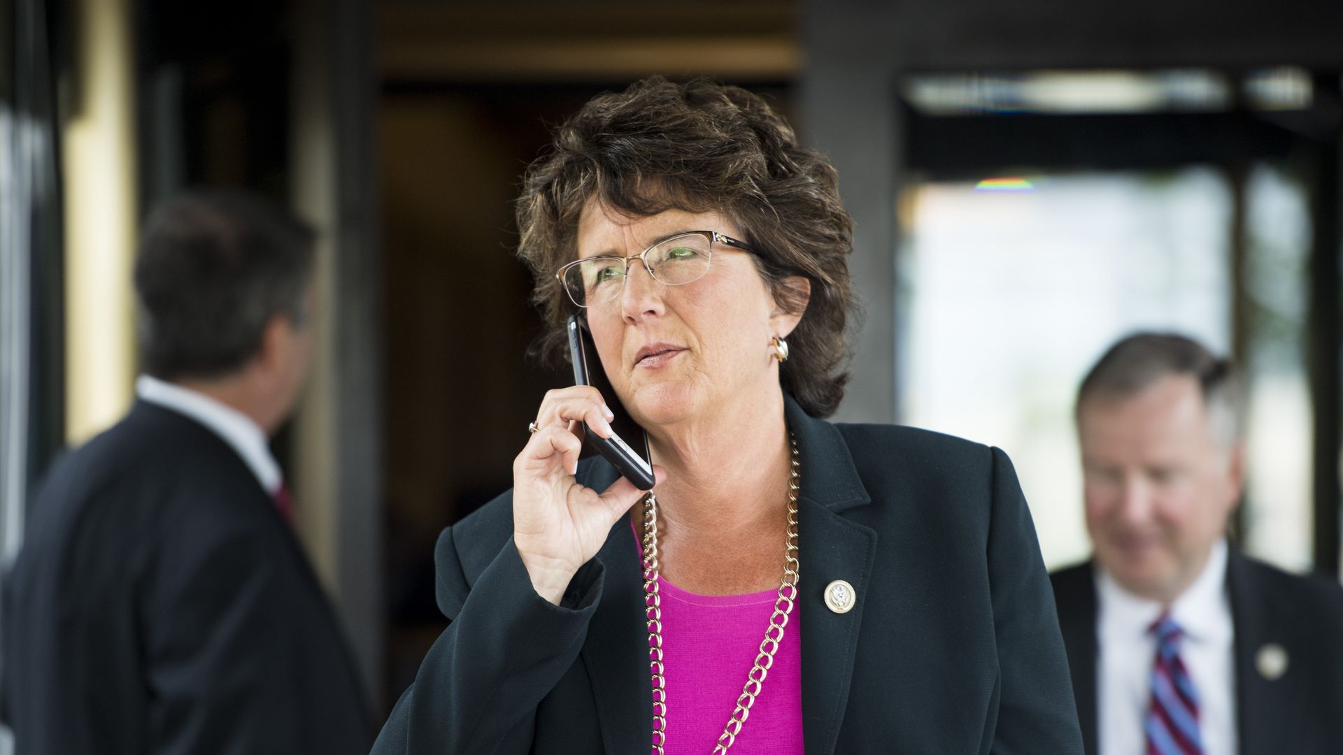Photo of Jackie Walorski holding a phone to her ear outside a building entrance