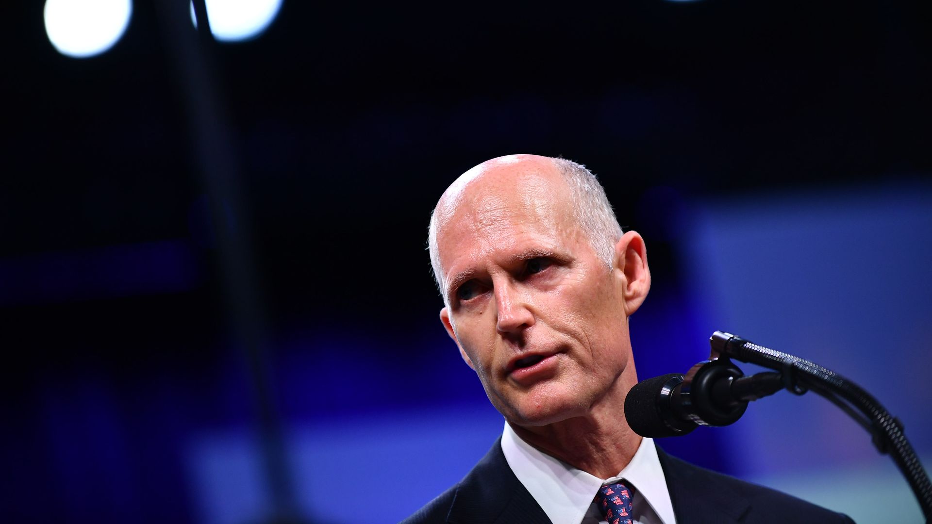 Florida Gov. Rick Scott at a microphone