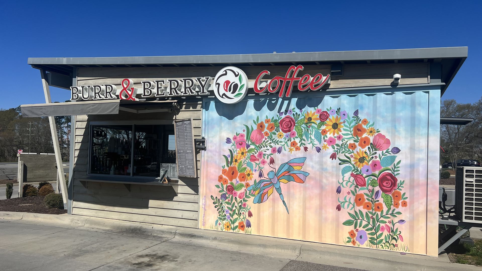 small coffee shop with a drive through and a sign that reads Burr and Berry Coffee