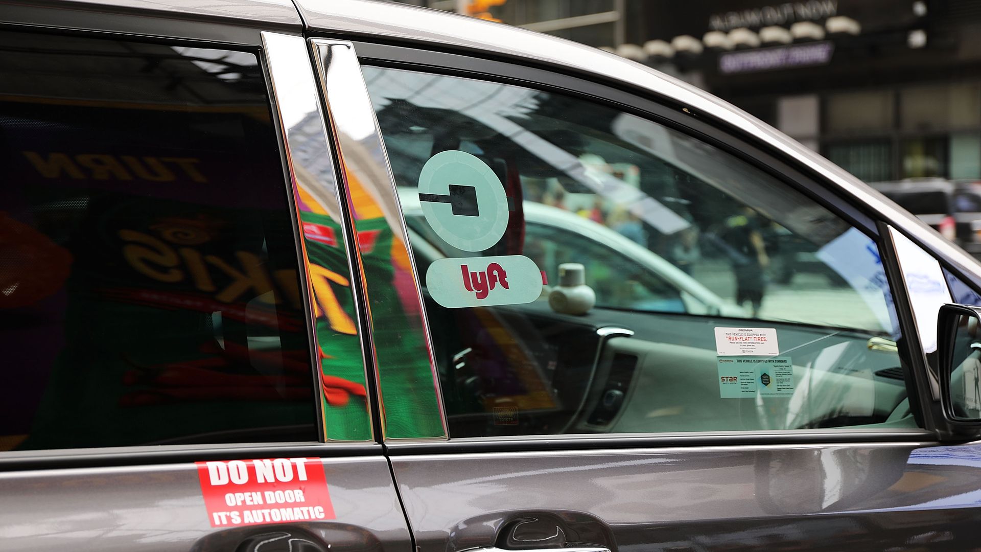 gray van with Uber and Lyft stickers on the window