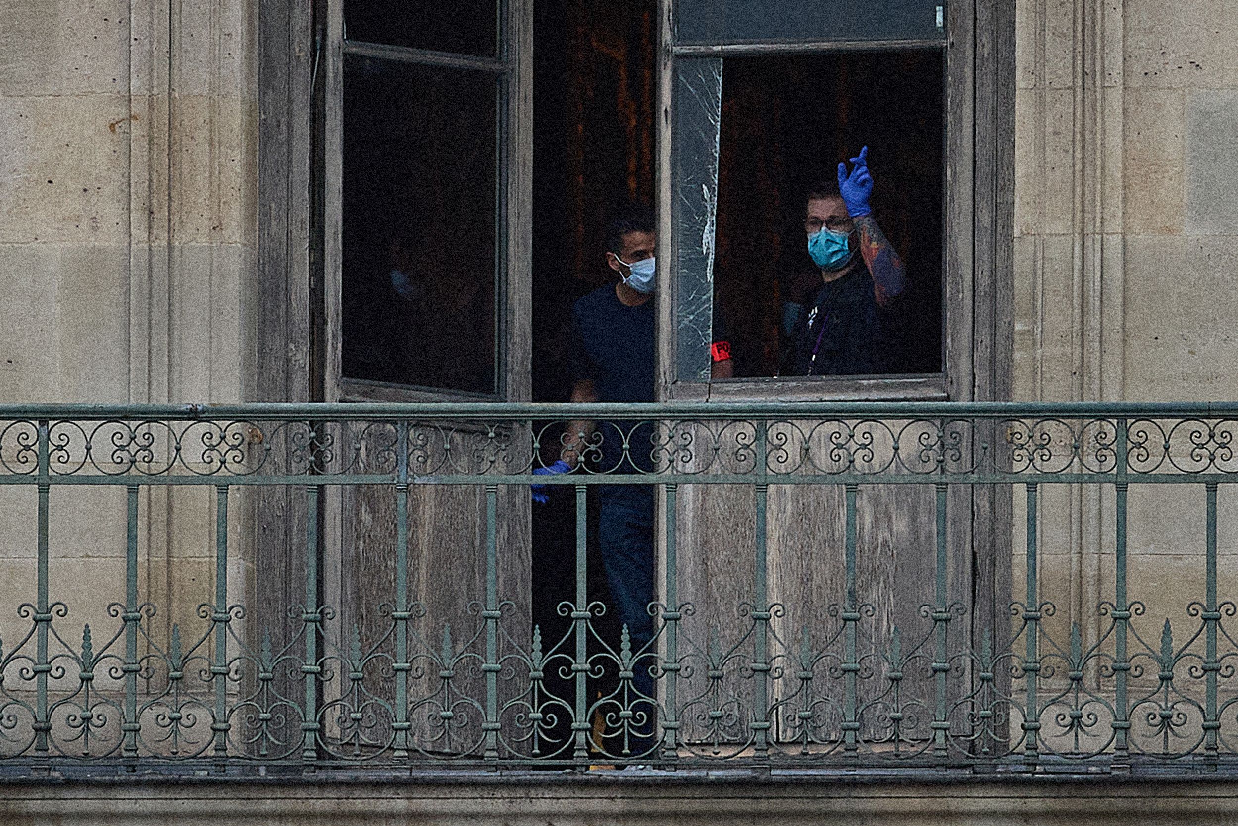 A French crime scene officer gestures toward a cut window at the Louvre Museum, believed to be the point of entry in an Oct. 19 robbery in Paris.