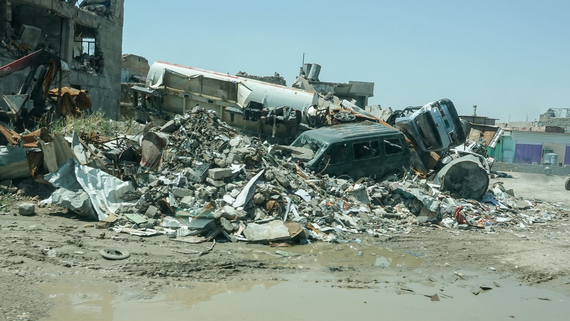 Houses and cars are that were destroyed by the Islamic State litter the city with debris.