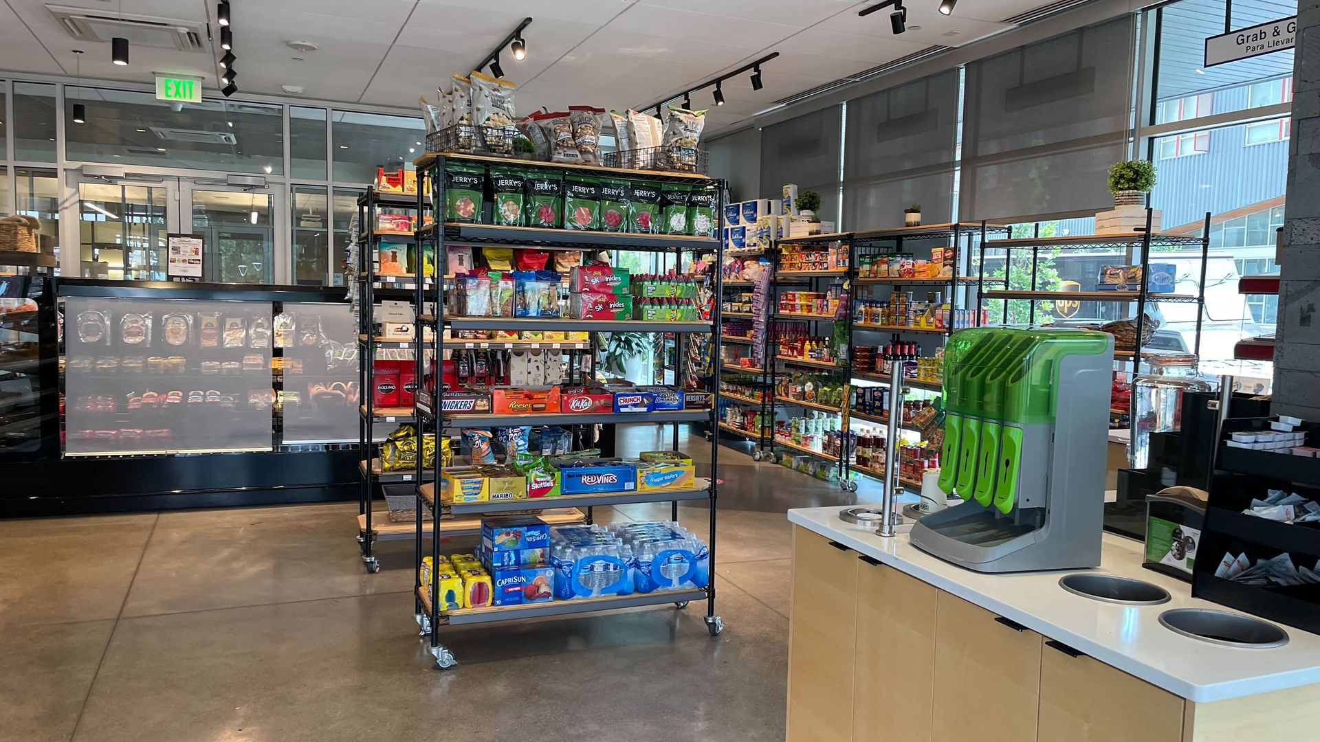 Inside a brightly-lit, small grocery store fill with various food items and produce. 