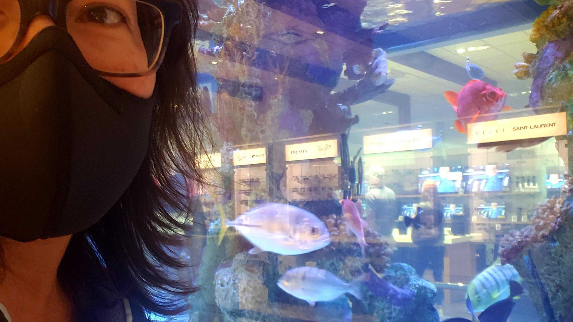 Photo of a woman in front of a fish tank. 
