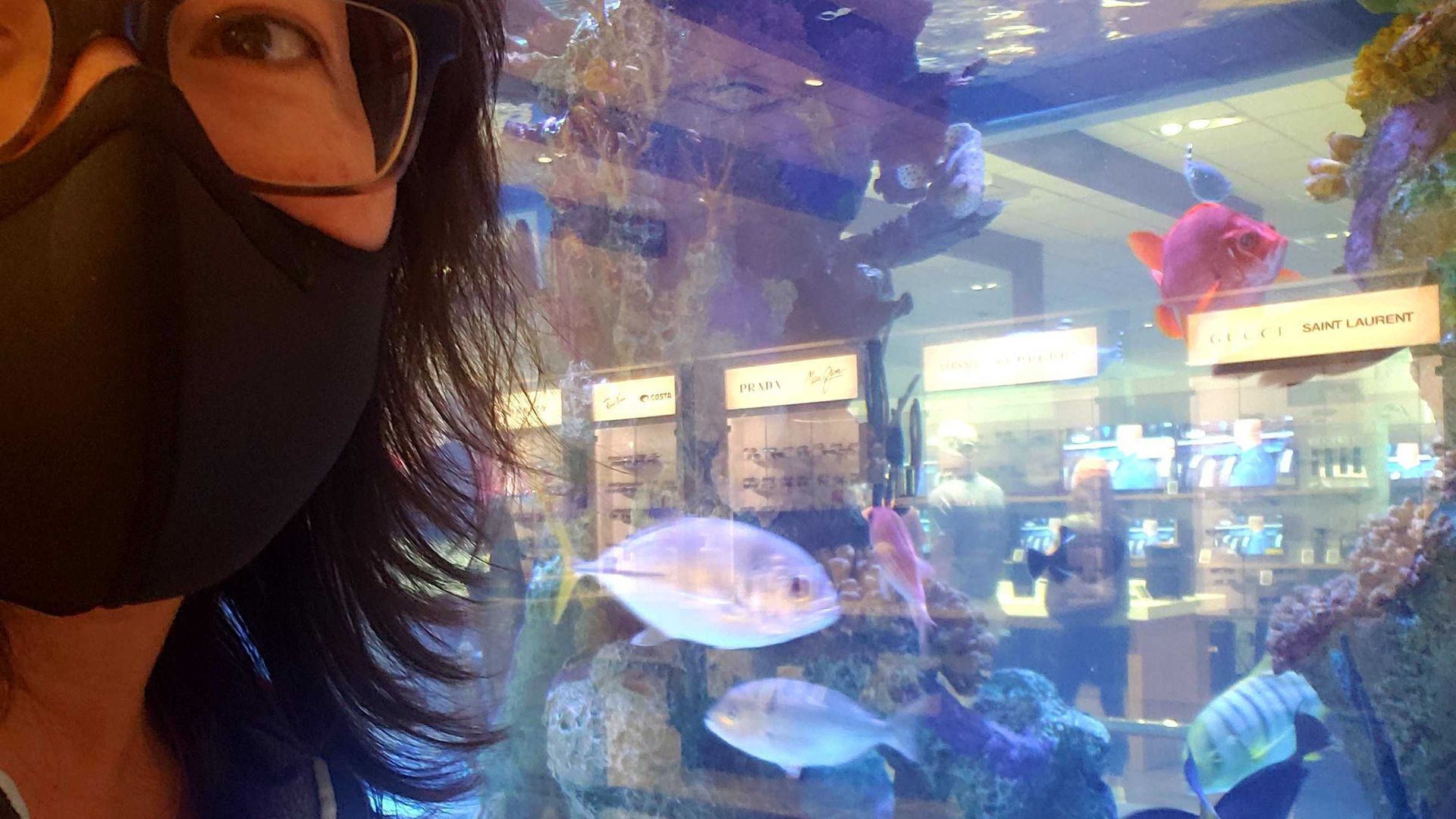 Photo of a woman in front of a fish tank.