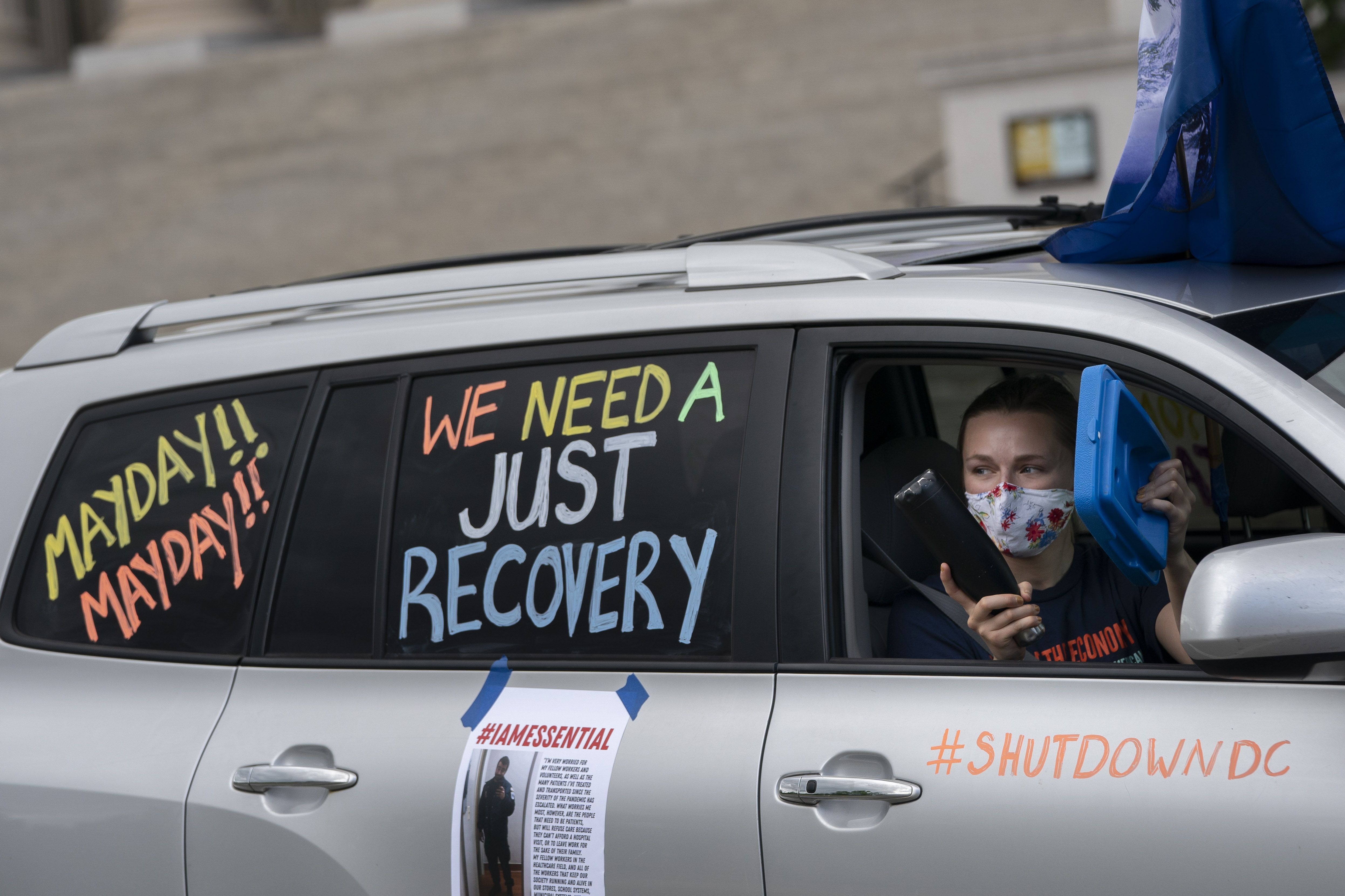 In this image, writing on a car reads: "Mayday! Mayday! we need a just recovery"