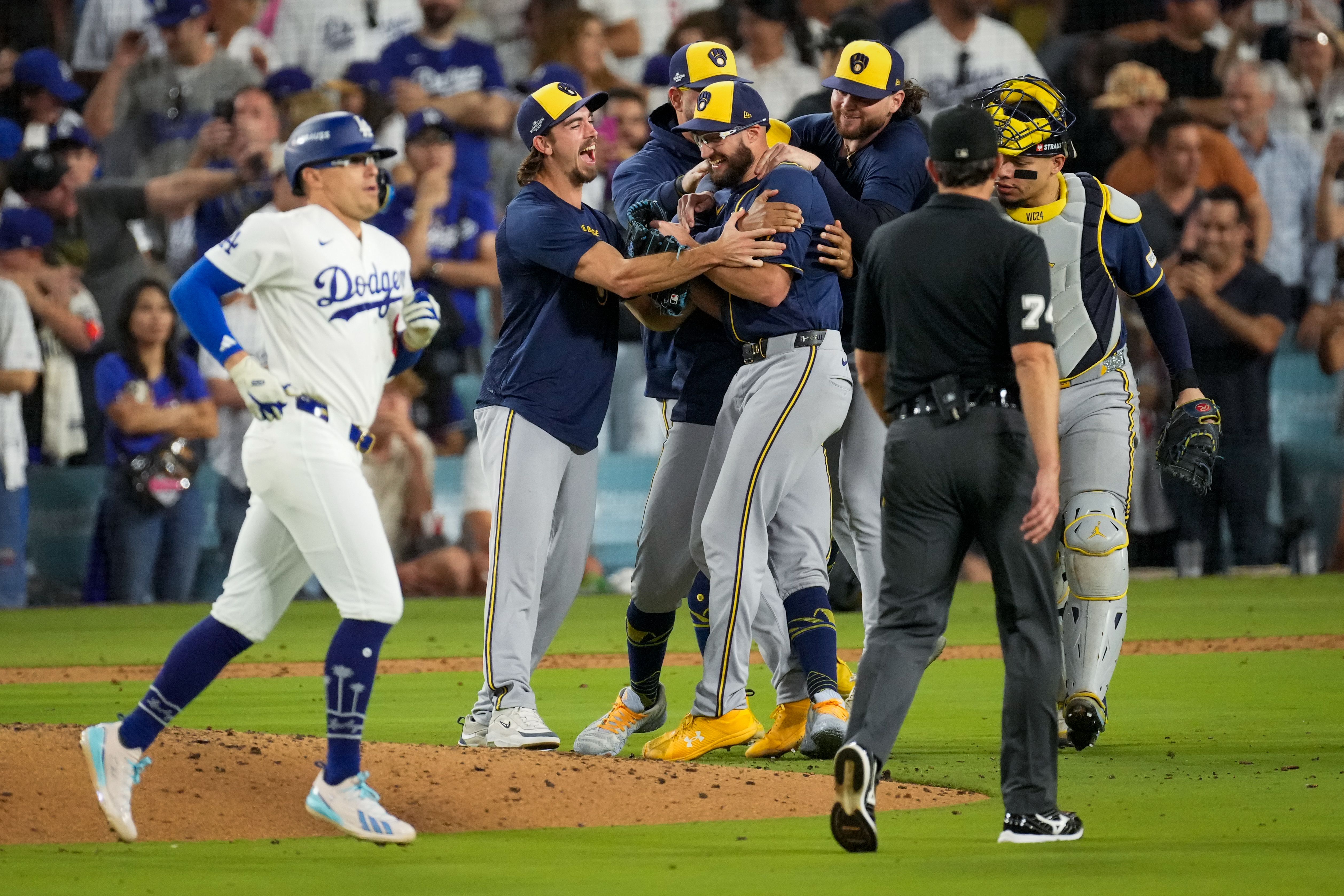 Los Angeles Dodgers third baseman Kiké Hernández leaves the field after making the final out as the Milwaukee Brewers celebrate at Dodger Stadium last night.
