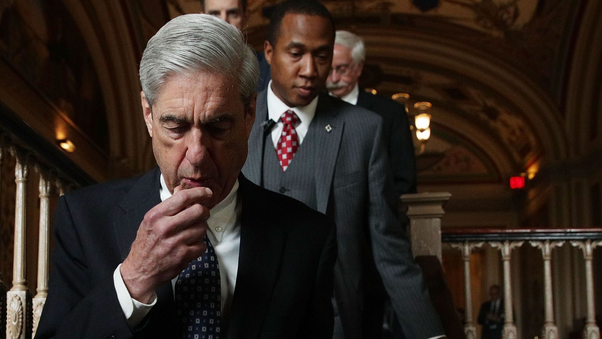 Robert Mueller walking downstairs with his hand to his chin
