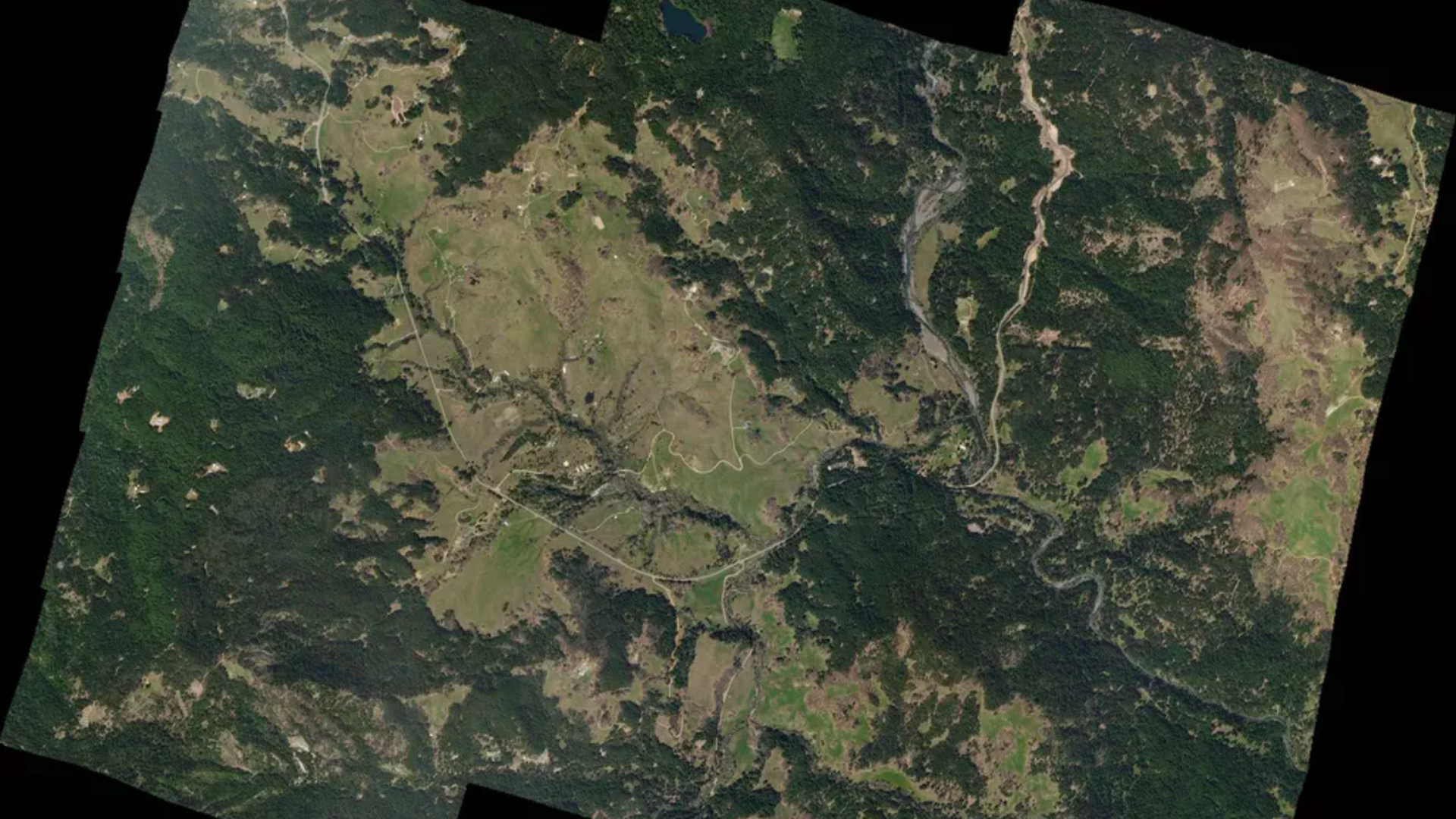 This image is a satellite image or birds eye view of a mountainous and forested region. 