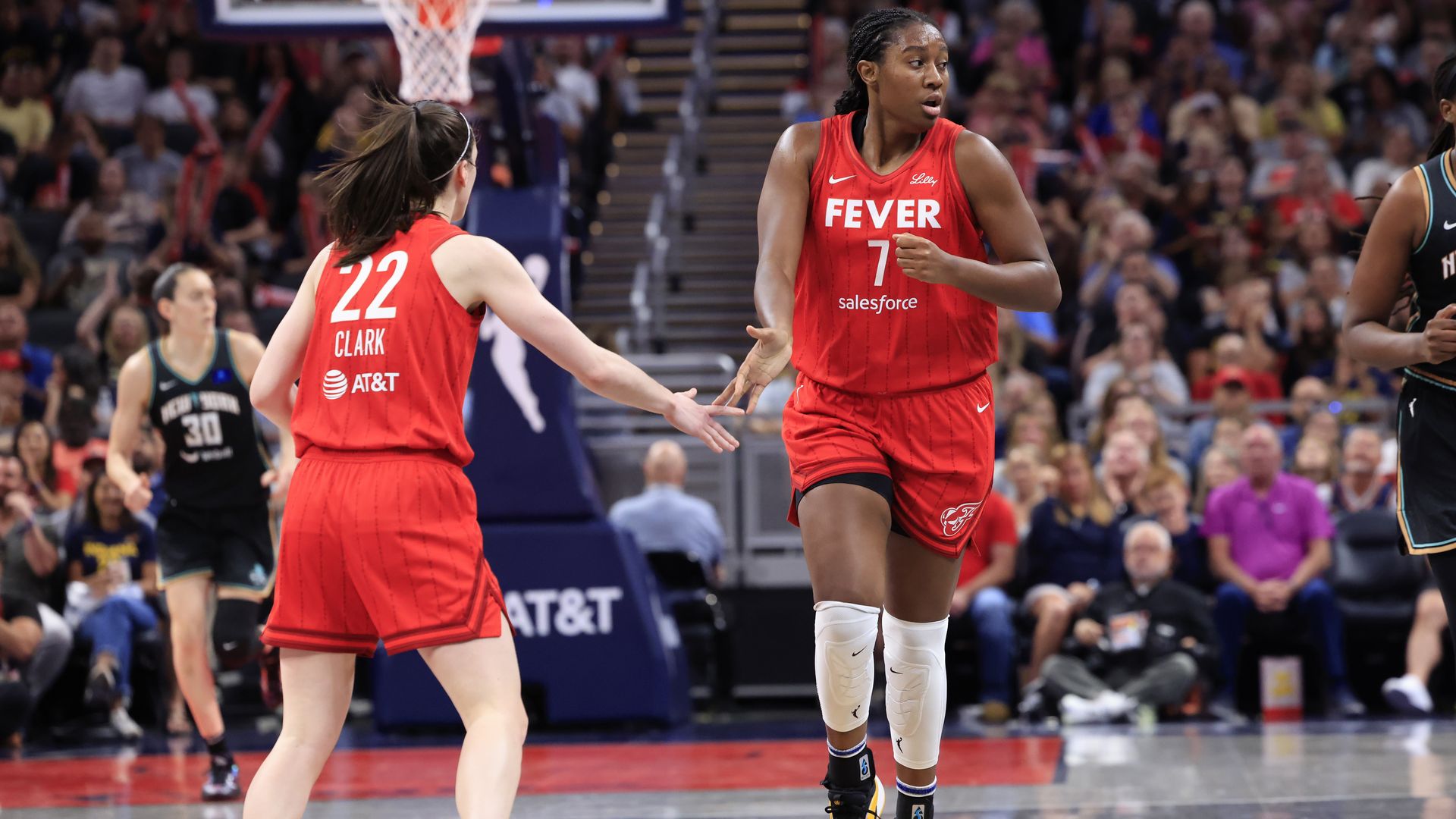 Caitlin Clark #22 and Aliyah Boston #7 of the Indiana Fever high five during the game against the New York Liberty