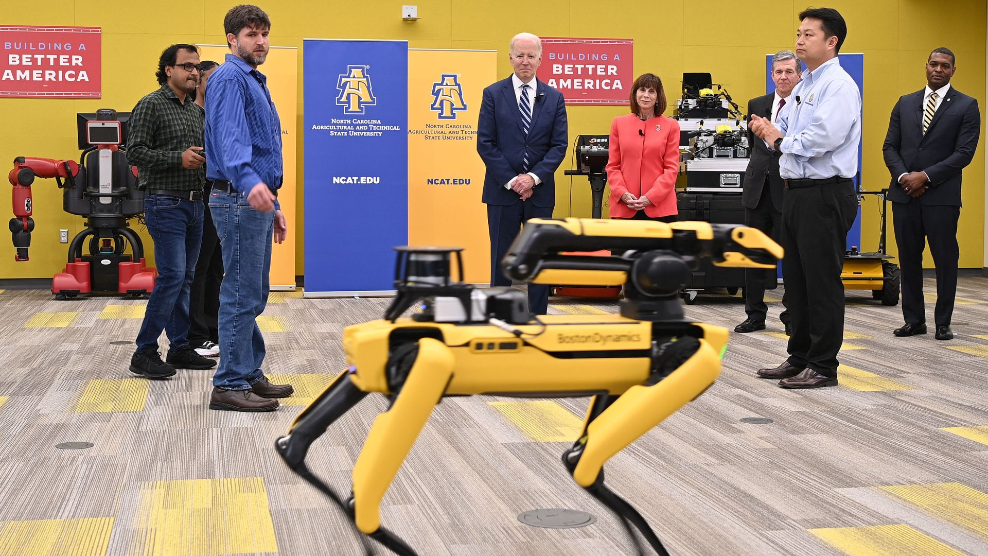 President Biden is seen looking at a robotic dog.