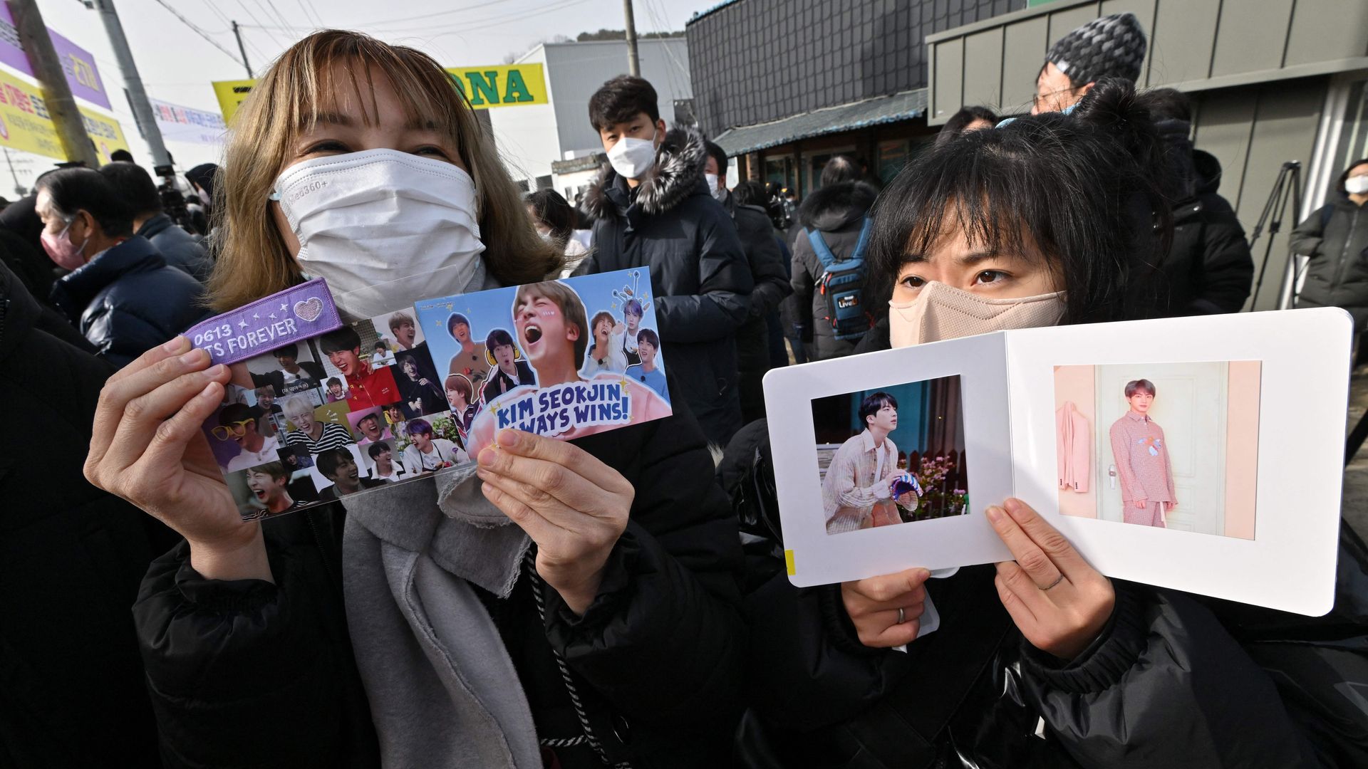 Fans hold pictures of BTS singer Jin in front of a military training unit in Yeoncheon on December 13, 2022